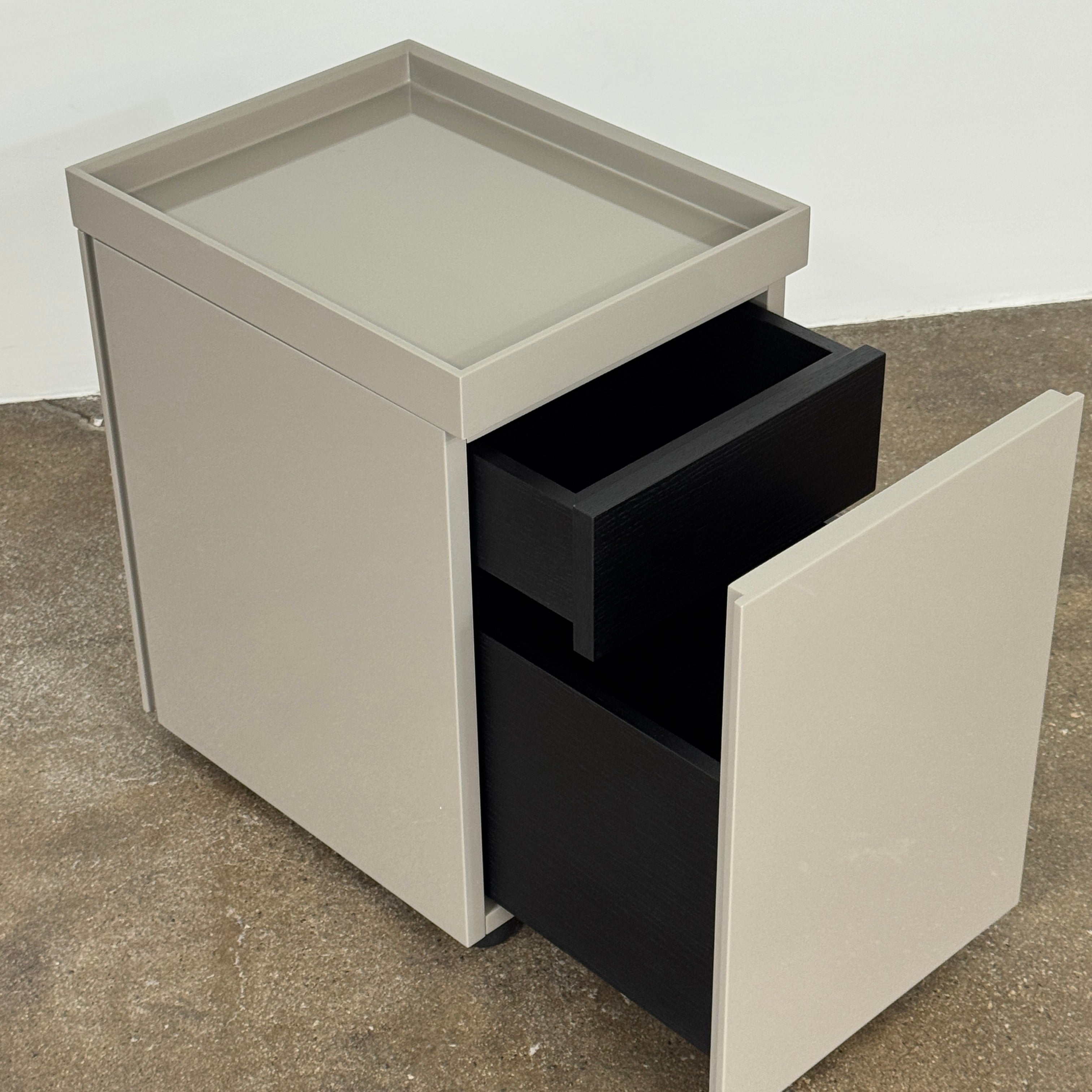 A Rev-A-Shelf instruction sheet and a "100% Thought&Made in Italy" leaflet sit on two beige trays, ideal for organizing your workspace or pairing with the Flexform Benjamin Chest of Drawers With File Insert.