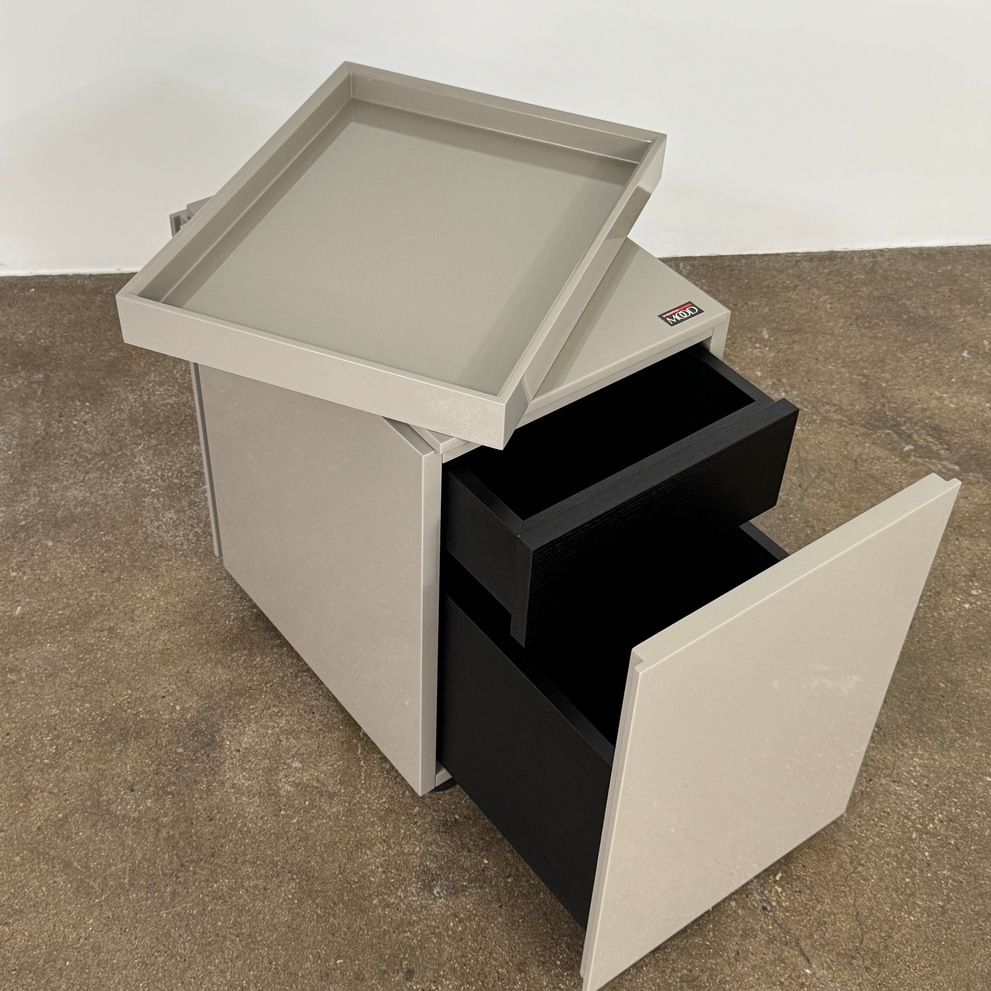 A Rev-A-Shelf instruction sheet and a "100% Thought&Made in Italy" leaflet sit on two beige trays, ideal for organizing your workspace or pairing with the Flexform Benjamin Chest of Drawers With File Insert.