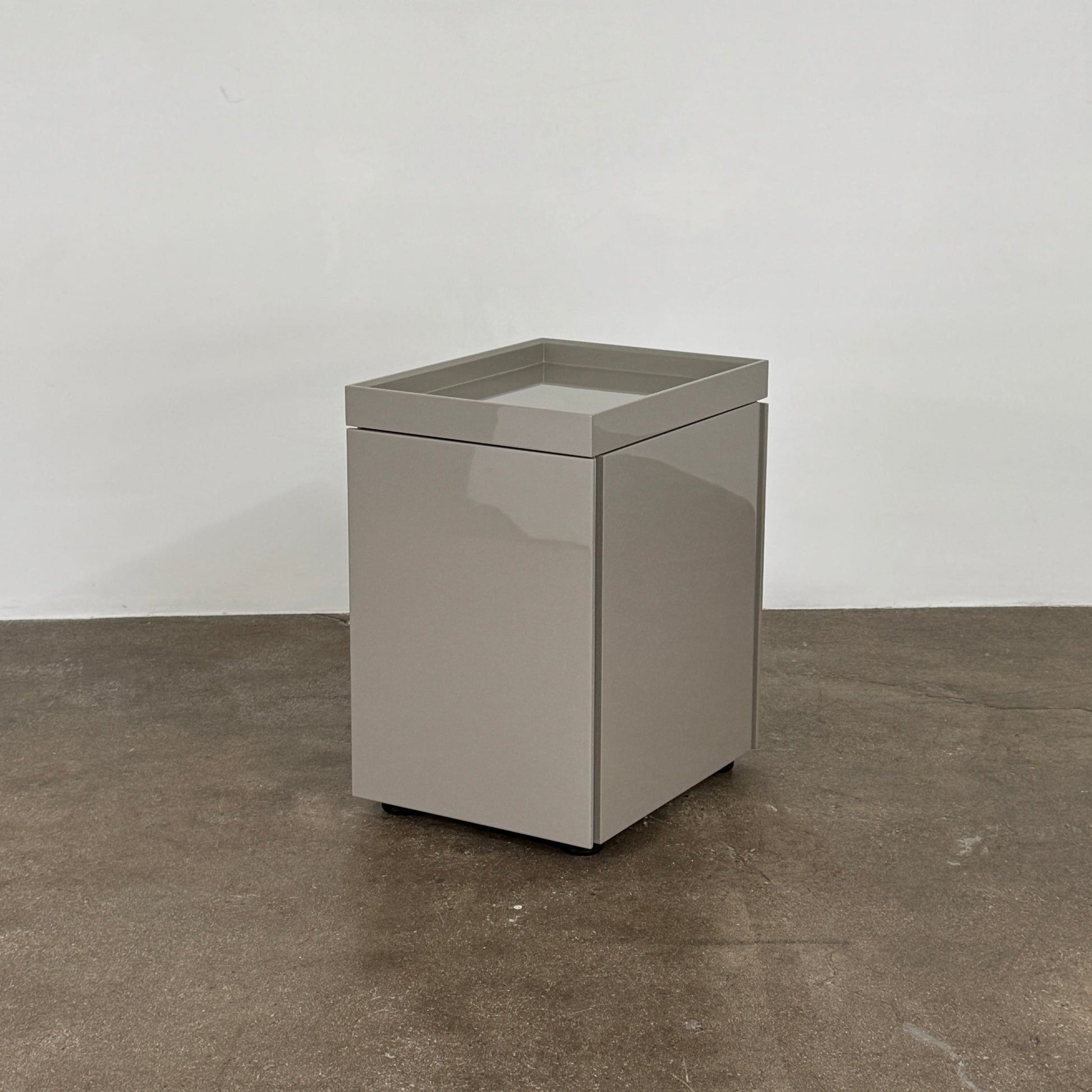 A Rev-A-Shelf instruction sheet and a "100% Thought&Made in Italy" leaflet sit on two beige trays, ideal for organizing your workspace or pairing with the Flexform Benjamin Chest of Drawers With File Insert.