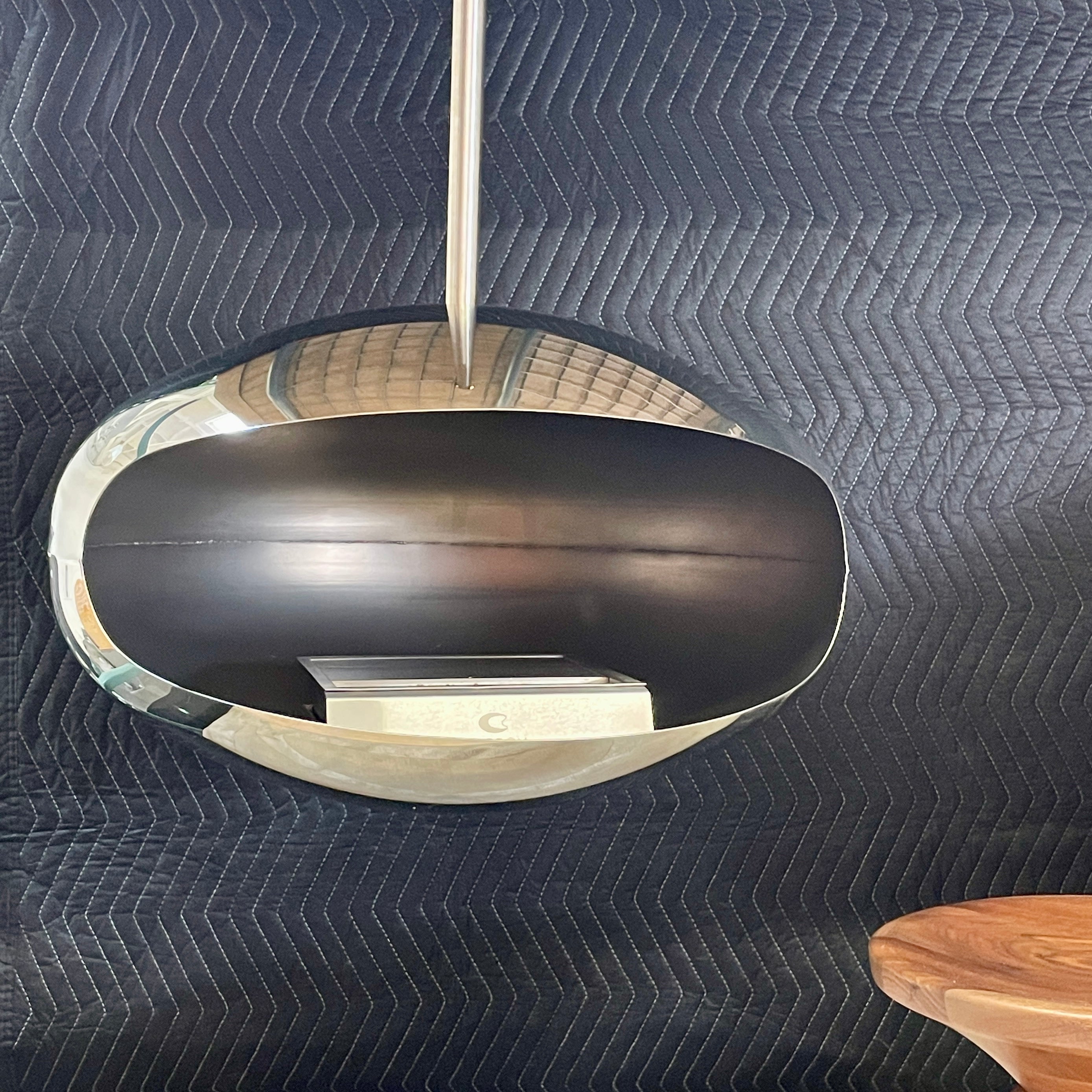 The Plushpod Cocoon Hanging Fireplace is a modern marvel with its oval design, sleek metallic finish, and reflective surface. Its rectangular opening radiates warmth and adds style to any space.