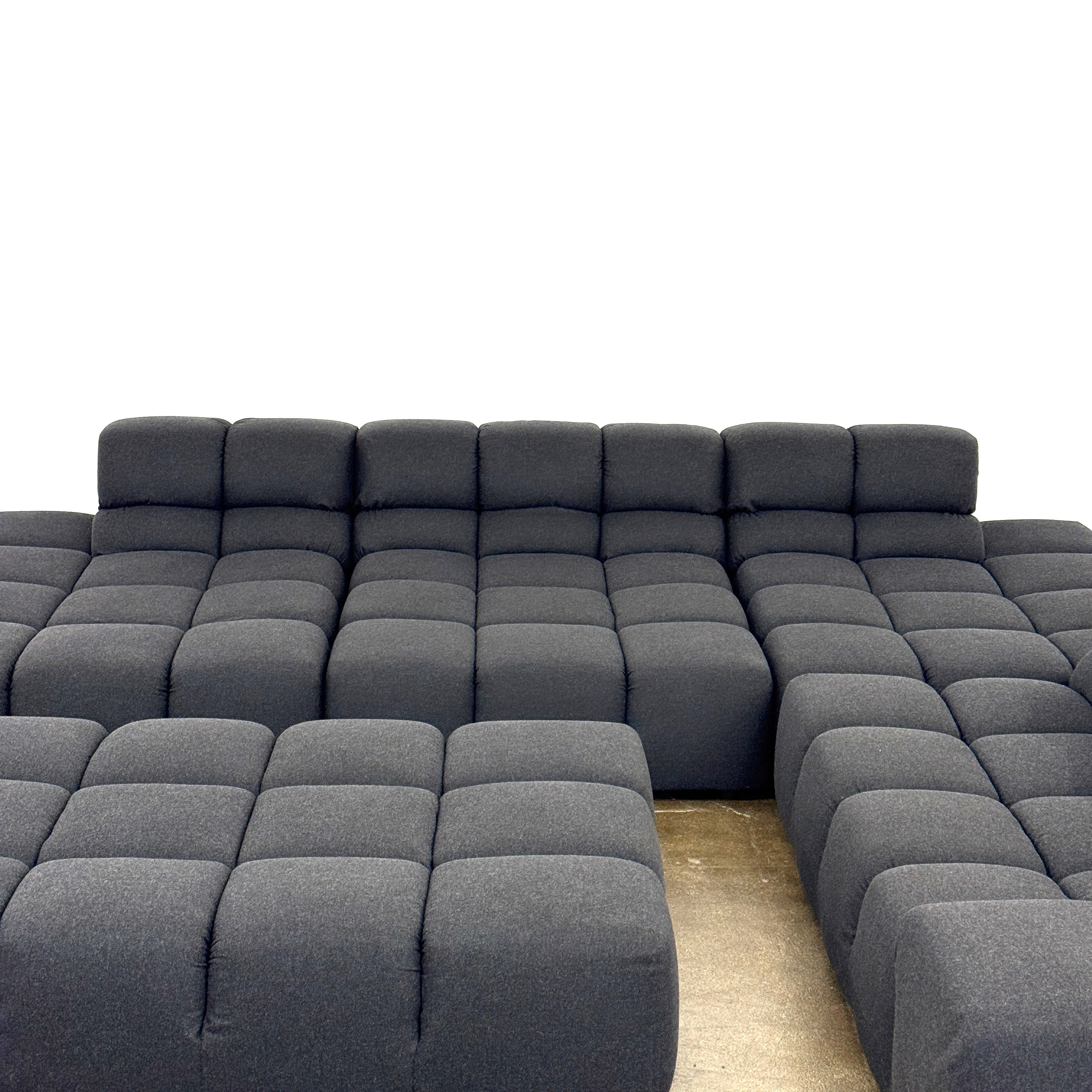 A B&B Italia 5 Piece Tufty Time Sectional with tufted cushions sits in an L-shape on a polished concrete floor against a plain white wall.