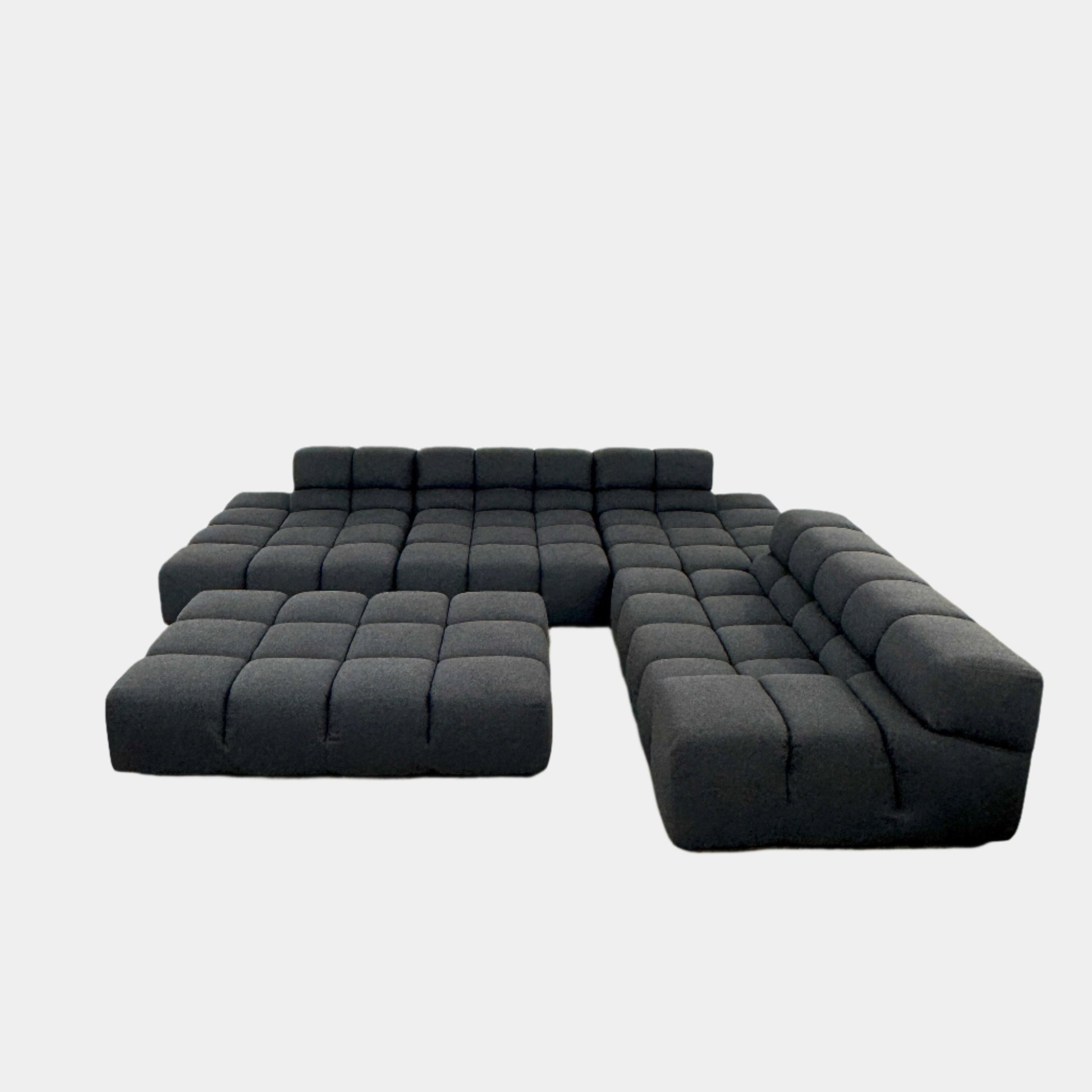 A B&B Italia 5 Piece Tufty Time Sectional with tufted cushions sits in an L-shape on a polished concrete floor against a plain white wall.