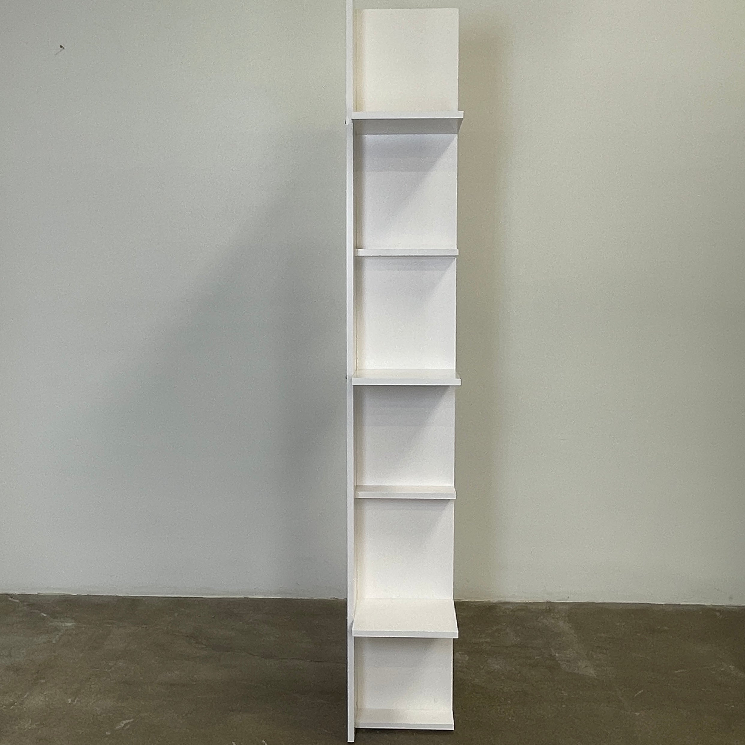 The Ligne Roset Everywhere Bookcase by Ligne Roset is a tall, modern white bookshelf with staggered geometric shelves.