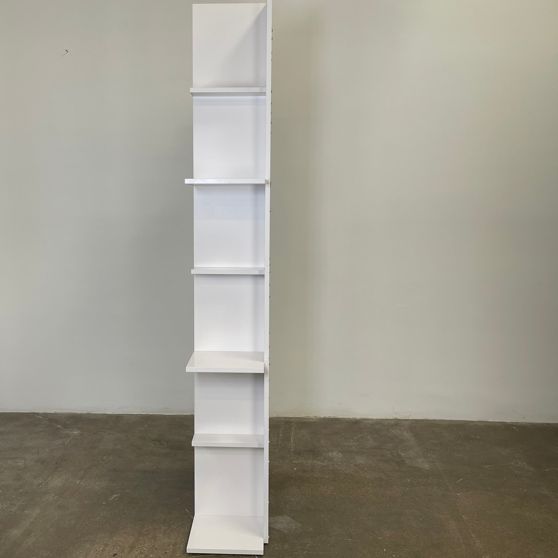 The Ligne Roset Everywhere Bookcase by Ligne Roset is a tall, modern white bookshelf with staggered geometric shelves.