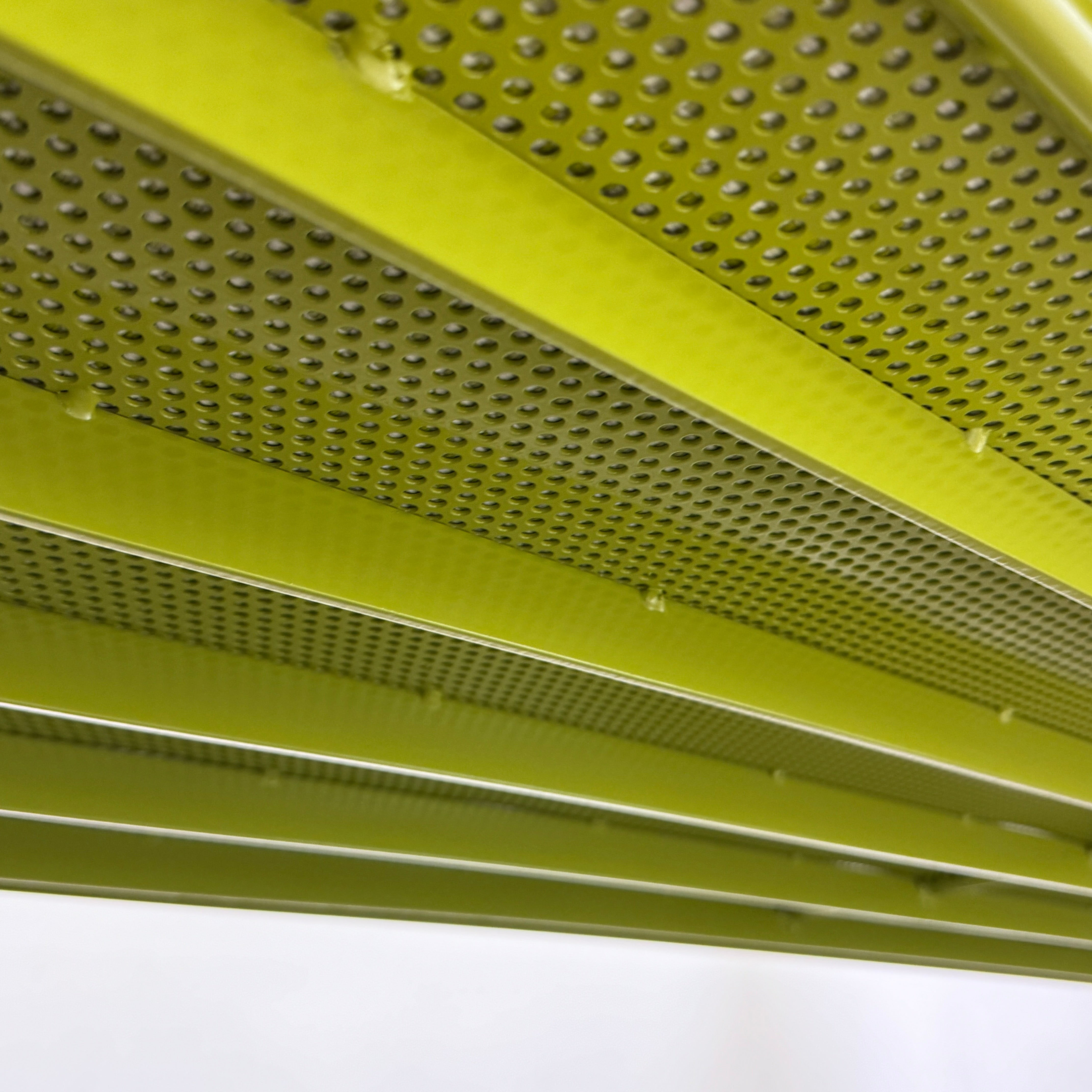 The light green Paola Lenti Kaba Outdoor Sofa by Modern Resale, featuring a metal frame, functions as a stylish two-seater and is shown against a plain white wall on a brown concrete floor.