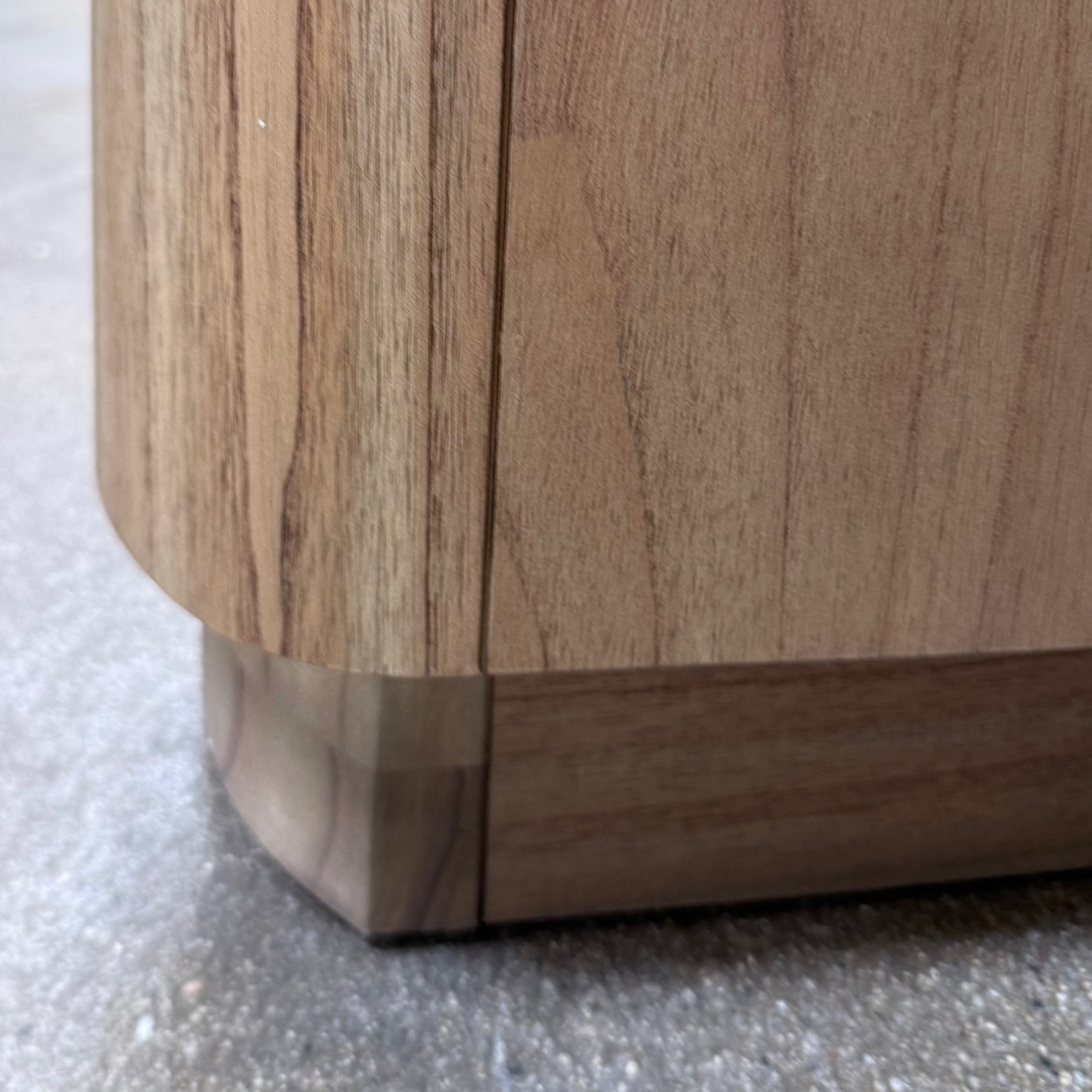 The Boa Small Cabinet by Fourhands features two doors, a gently curved front, light natural wood finish, and round handles, bringing contemporary style to any space.