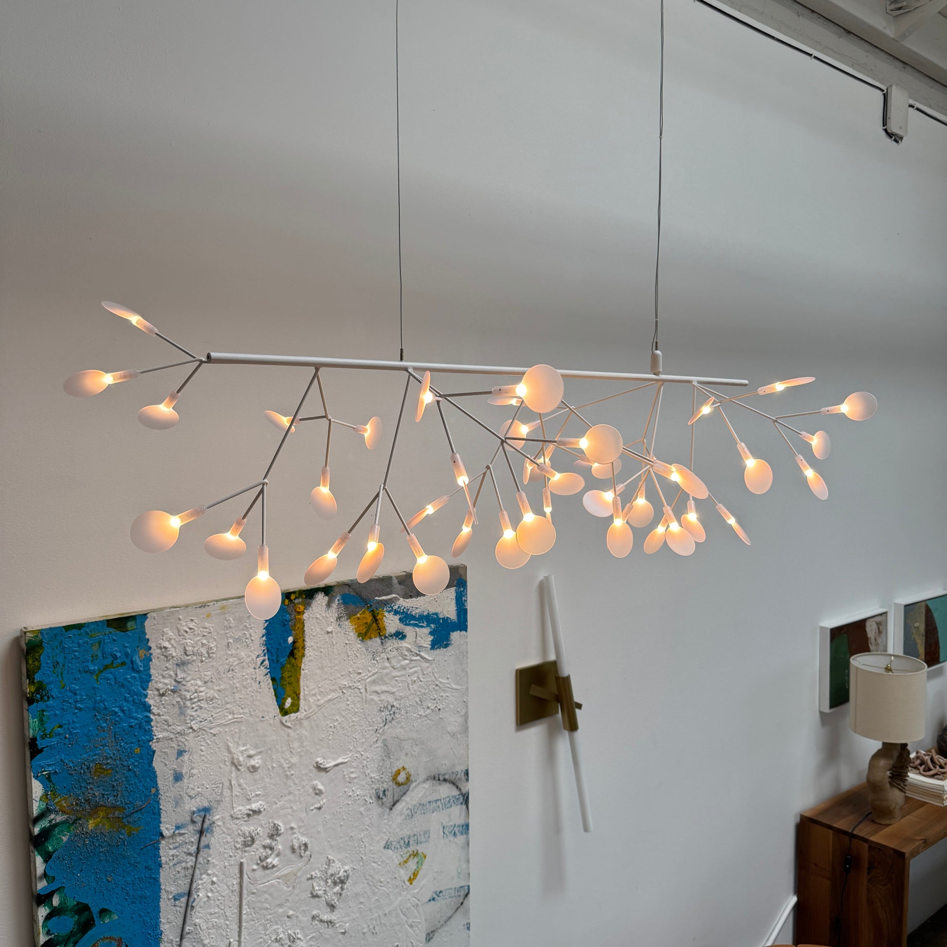 The Moooi Heracleum Endless LED Suspension Lamp-White is a modern chandelier featuring multiple radial branches ending in circular light diffusers, hanging from a single cord attached to a round ceiling mount.