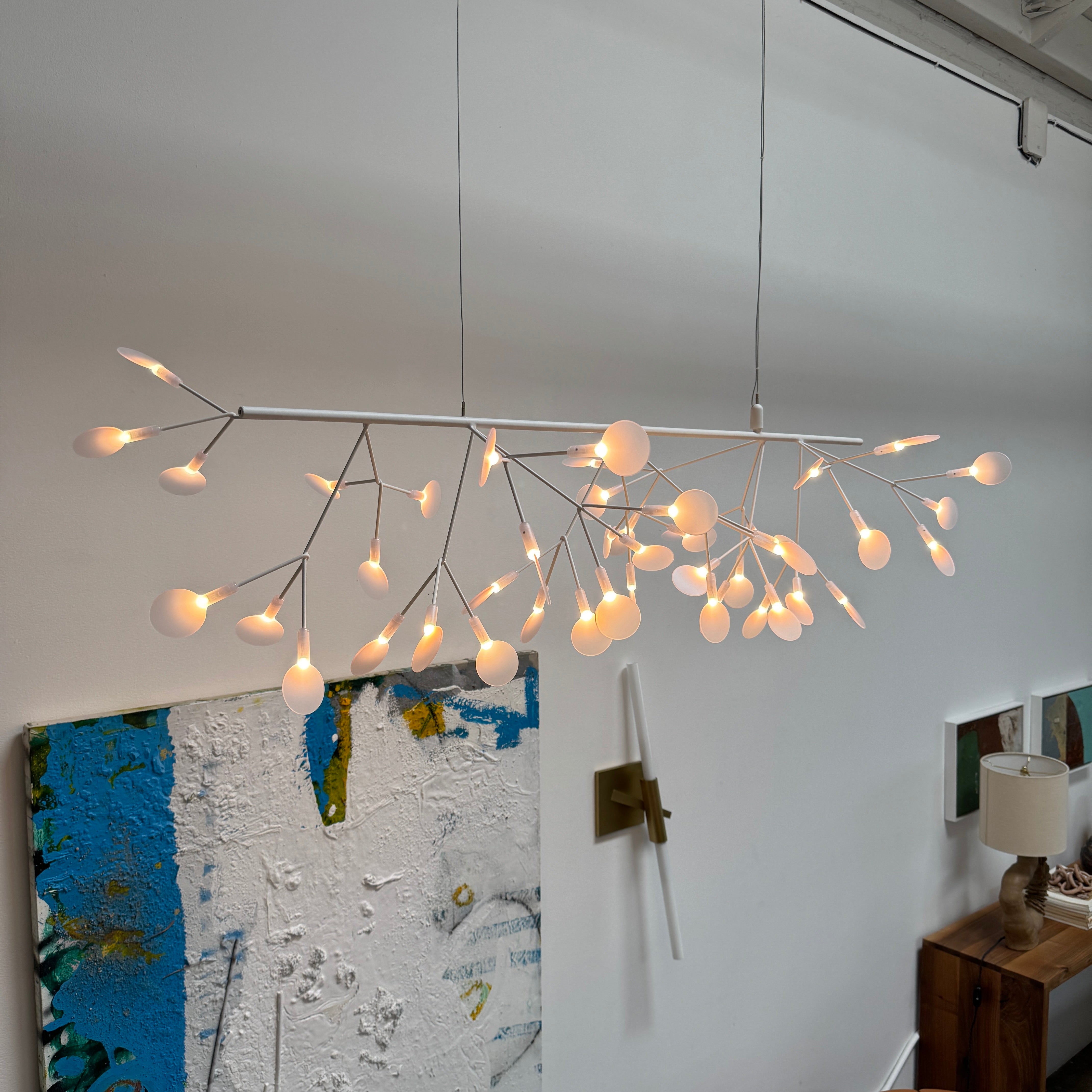 The Moooi Heracleum Endless LED Suspension Lamp-White is a modern chandelier featuring multiple radial branches ending in circular light diffusers, hanging from a single cord attached to a round ceiling mount.