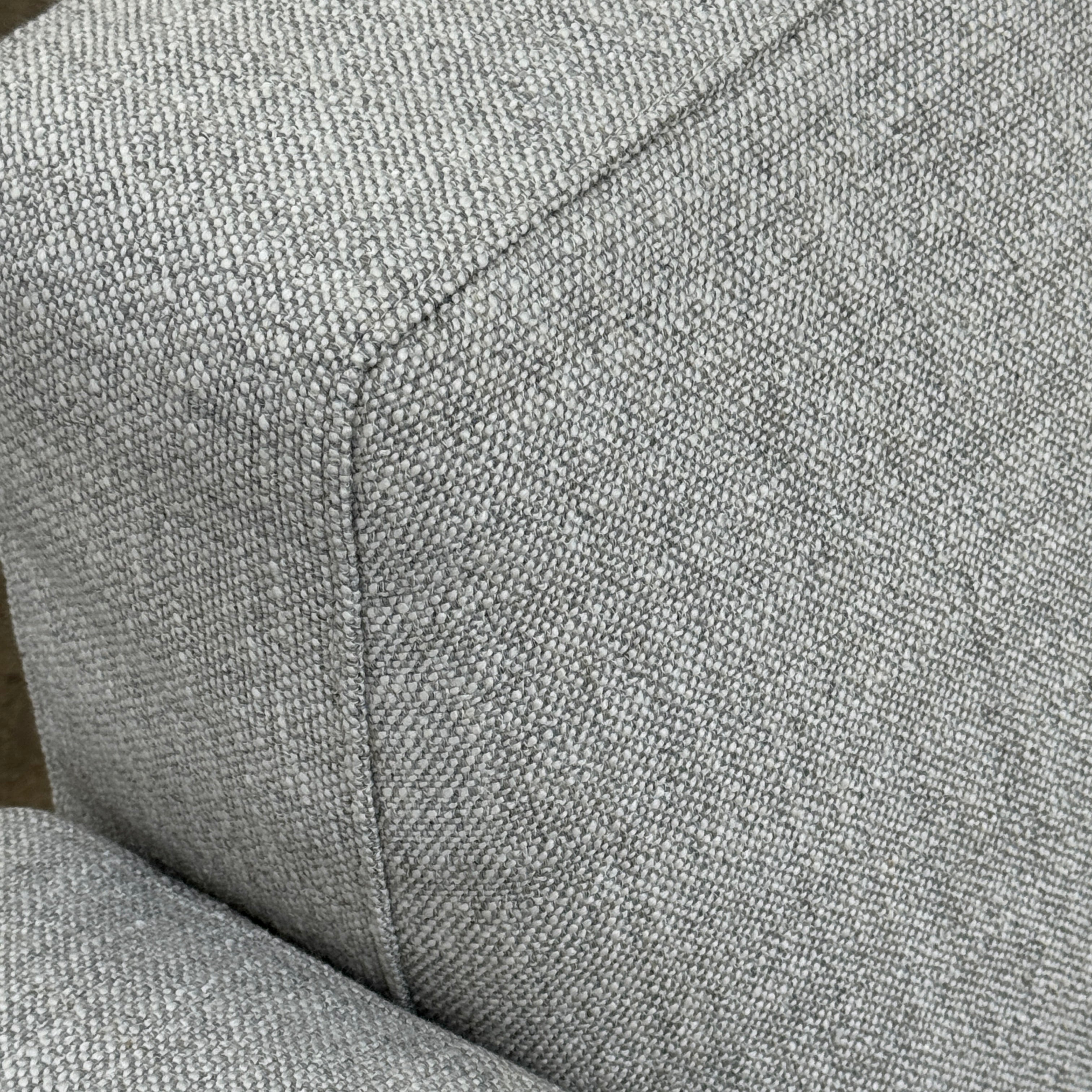 A contemporary Flexform Dream Sofa in light gray, featuring wide armrests and black metal legs, is displayed against a plain white background.