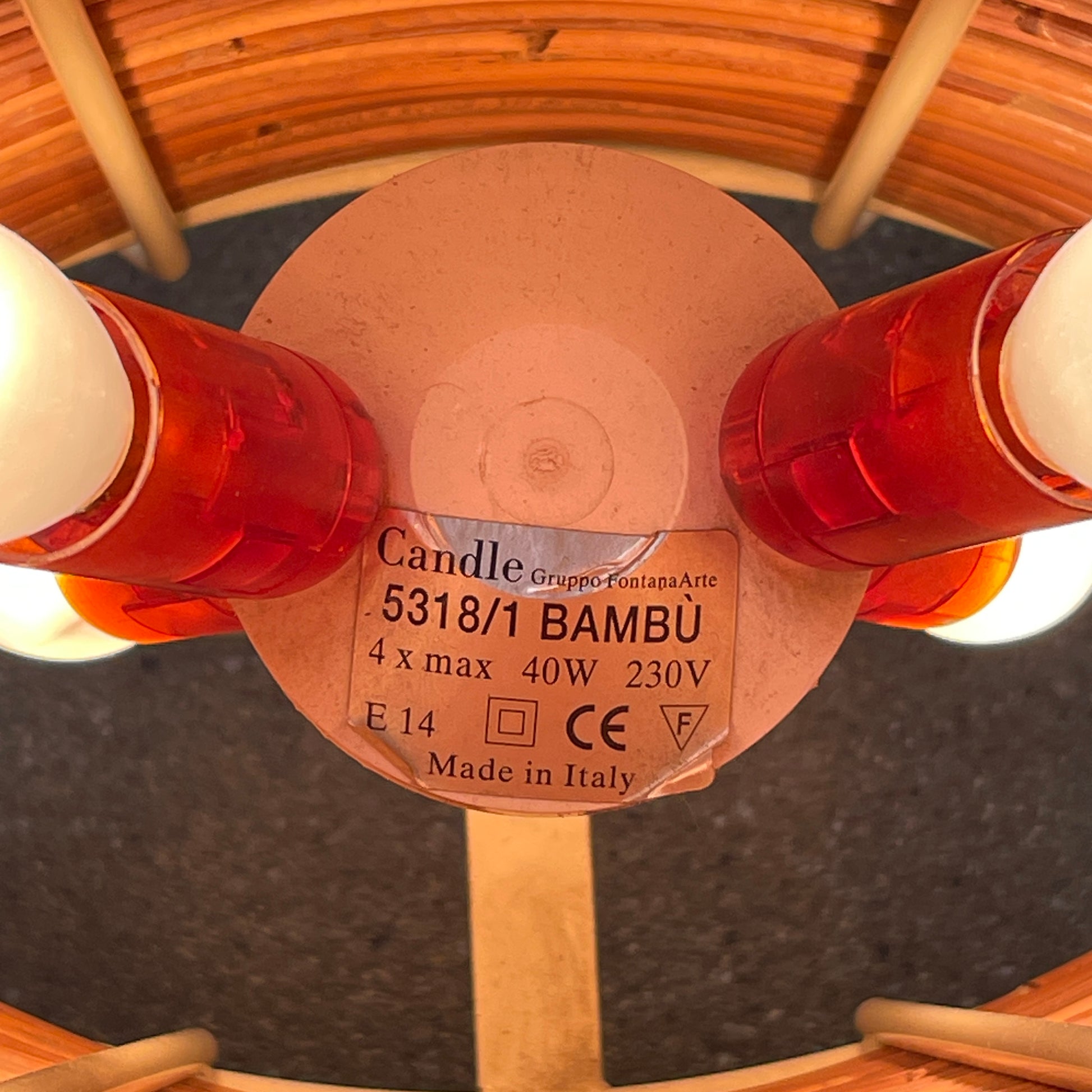 The Vintage Fontana Arte Bambú Table Light by Fontana Arte showcases a woven rattan circular shade atop a sleek white metal tripod base, making it an elegant addition to a wooden table. This lamp enhances your home's interior lighting with its natural charm and unique design.