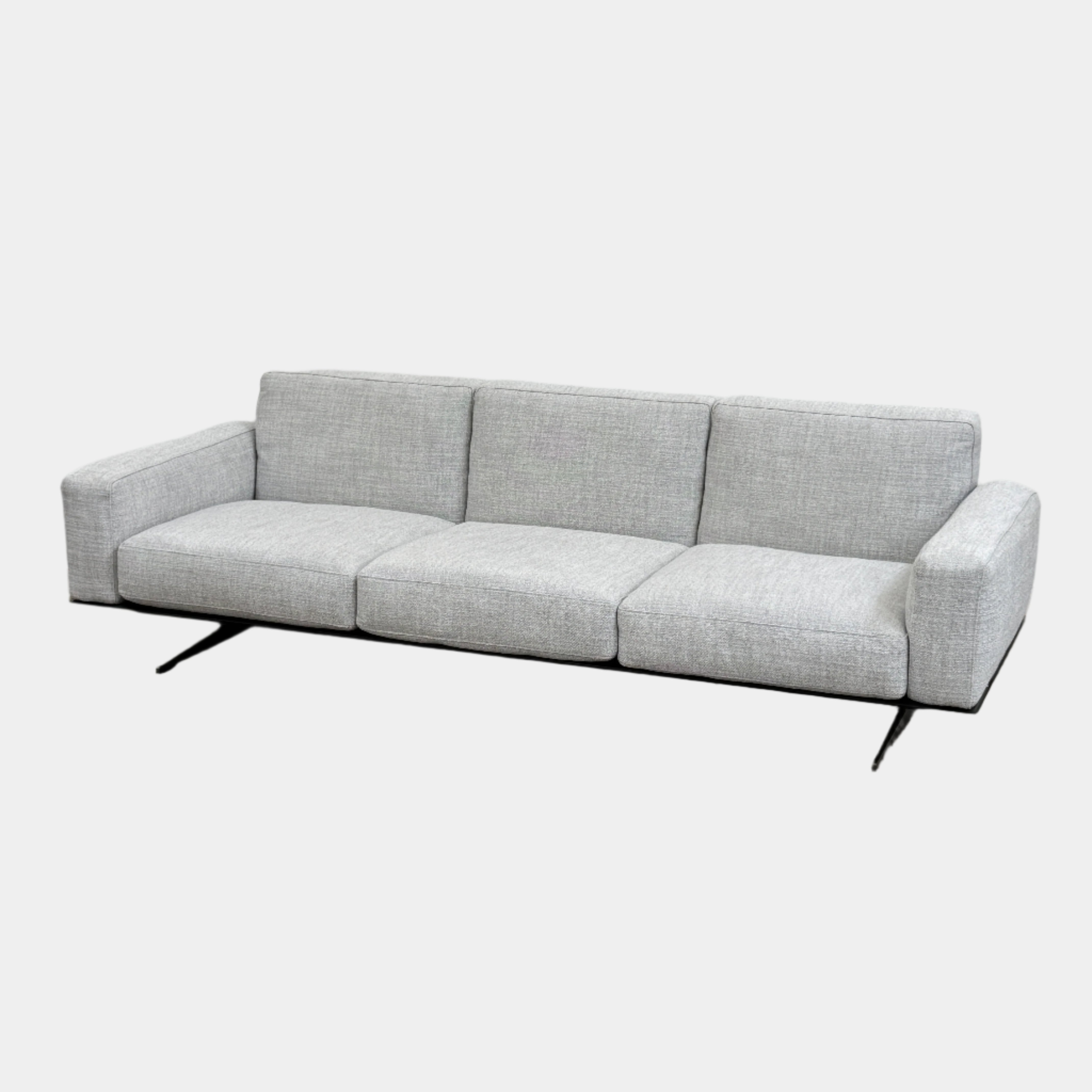 A contemporary Flexform Dream Sofa in light gray, featuring wide armrests and black metal legs, is displayed against a plain white background.