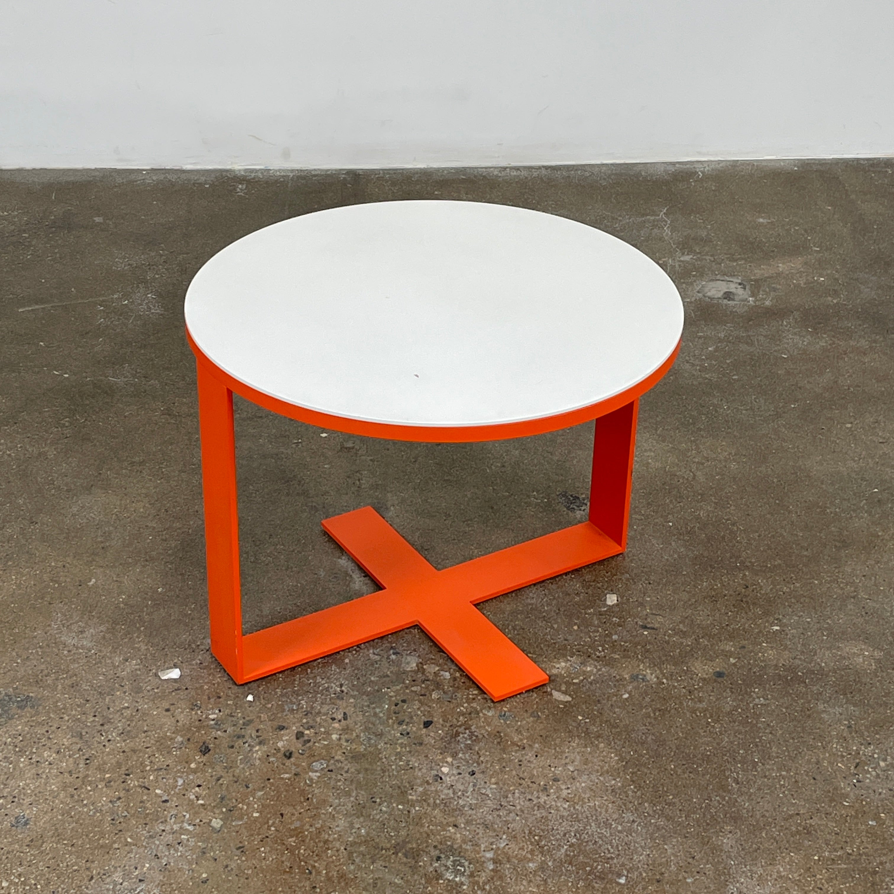 Two modern B&B Italia Eileen tables, featuring white lacquer tops and vibrant orange frames, come in varying heights and unique designs to add a stylish touch to any living space.