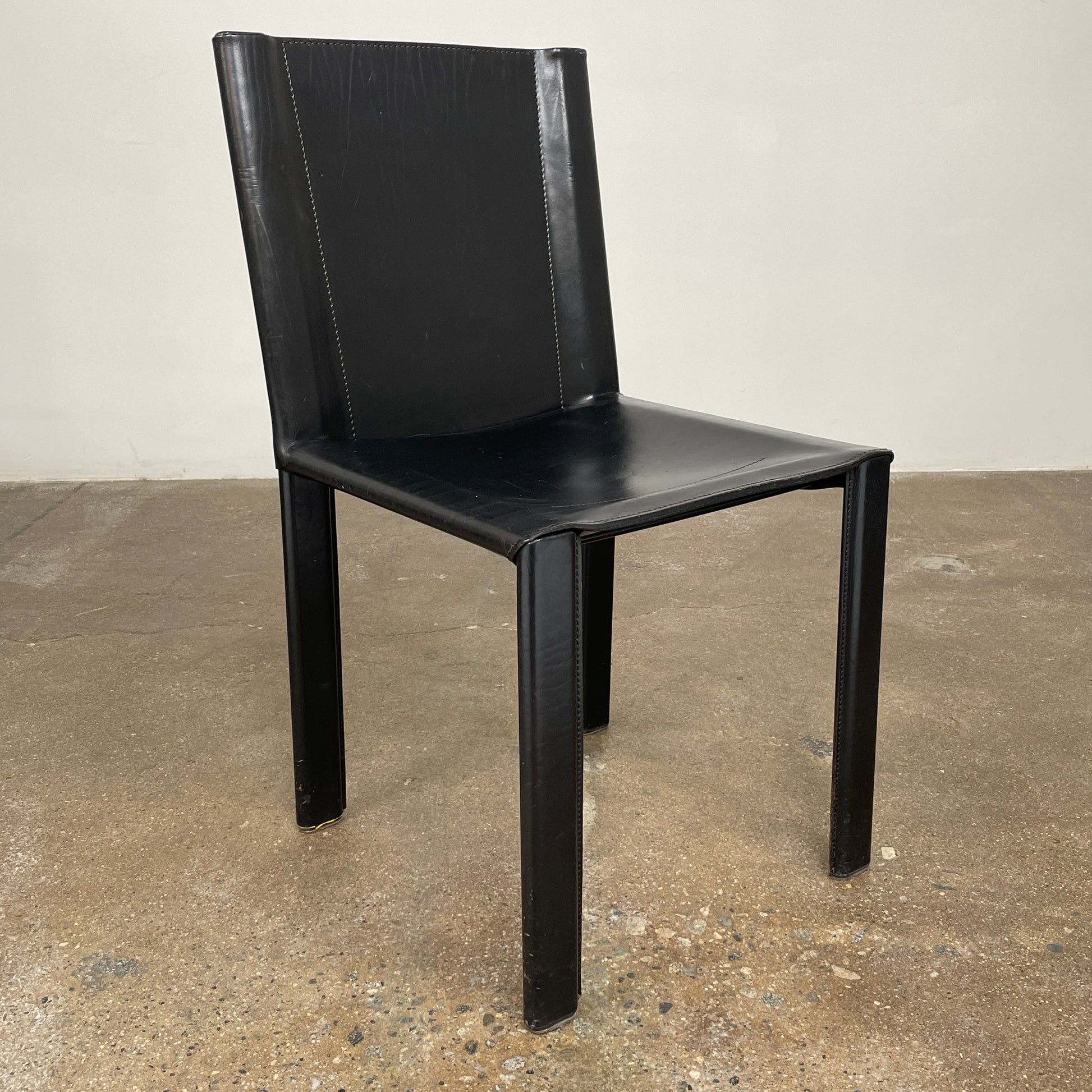 Eight Vintage Matteo Grassi 'Coral' dining chairs, showcasing a sleek black finish, are arranged in two rows on a pristine white background.