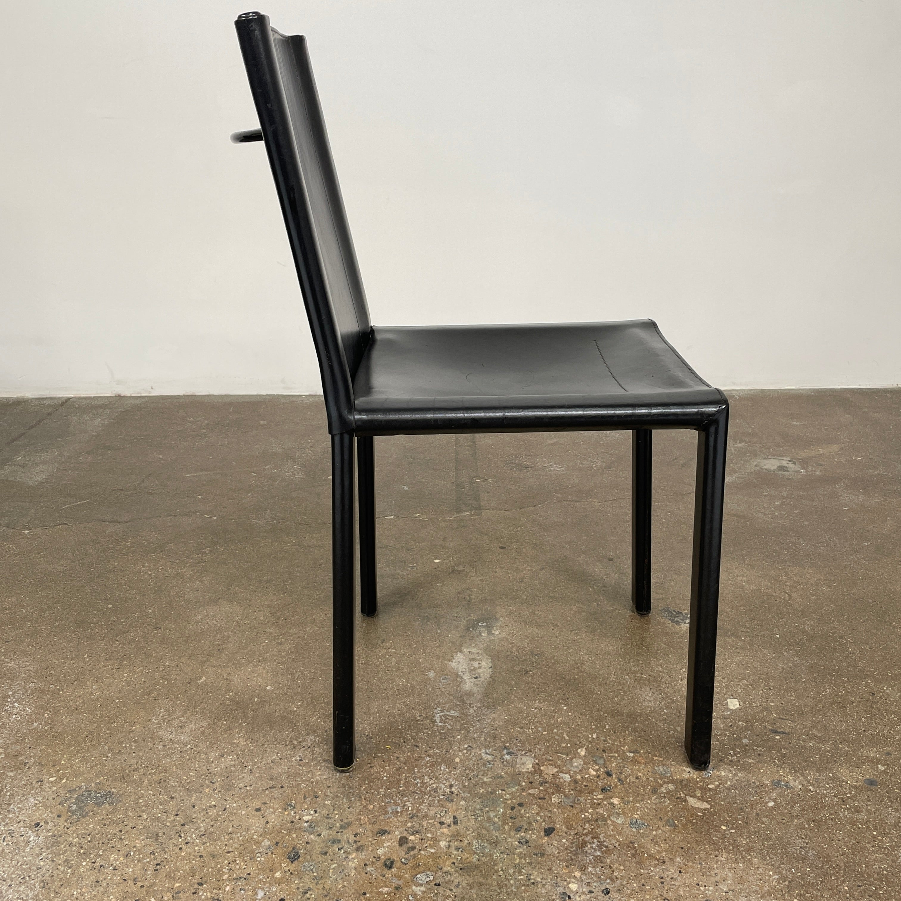 Eight Vintage Matteo Grassi 'Coral' dining chairs, showcasing a sleek black finish, are arranged in two rows on a pristine white background.