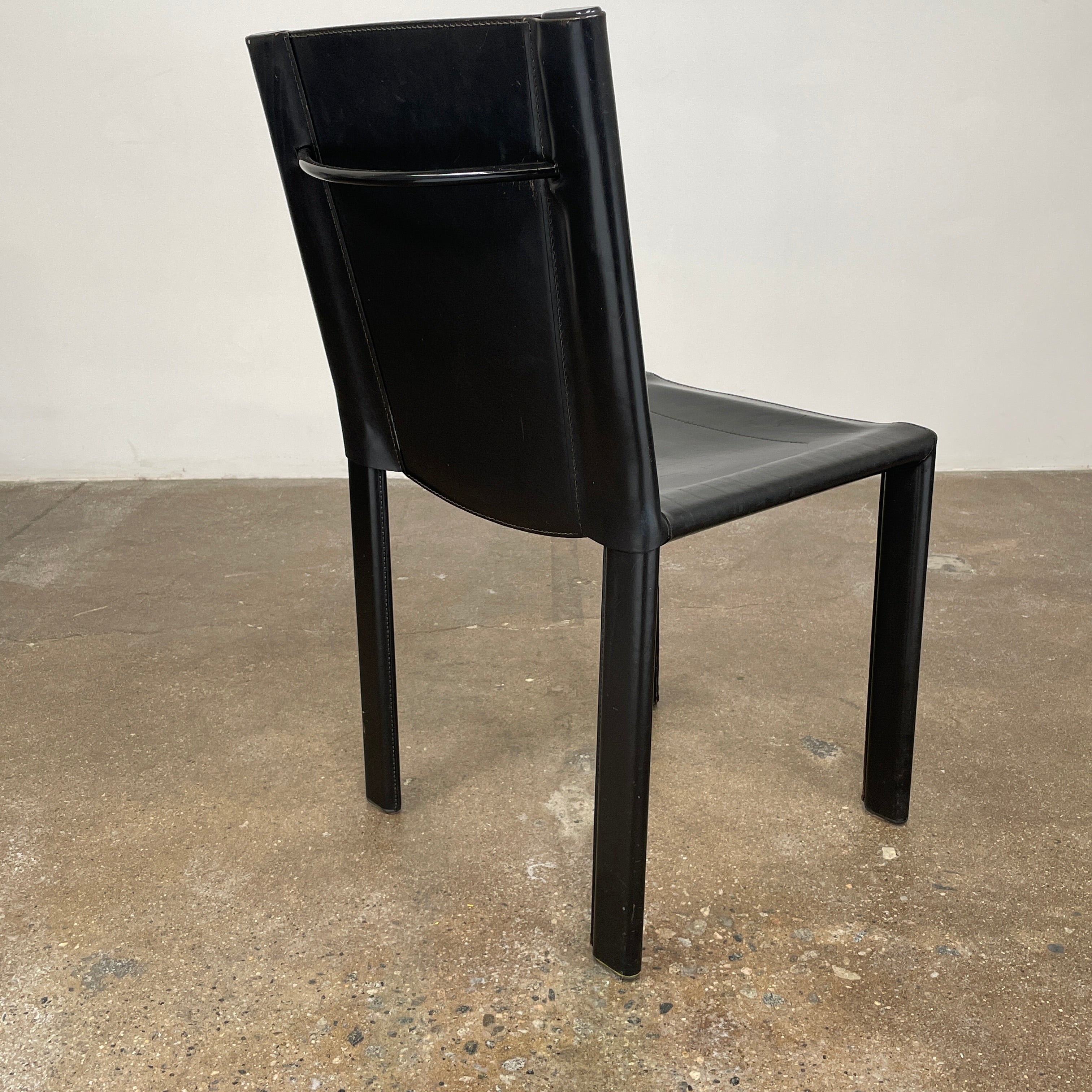 Eight Vintage Matteo Grassi 'Coral' dining chairs, showcasing a sleek black finish, are arranged in two rows on a pristine white background.