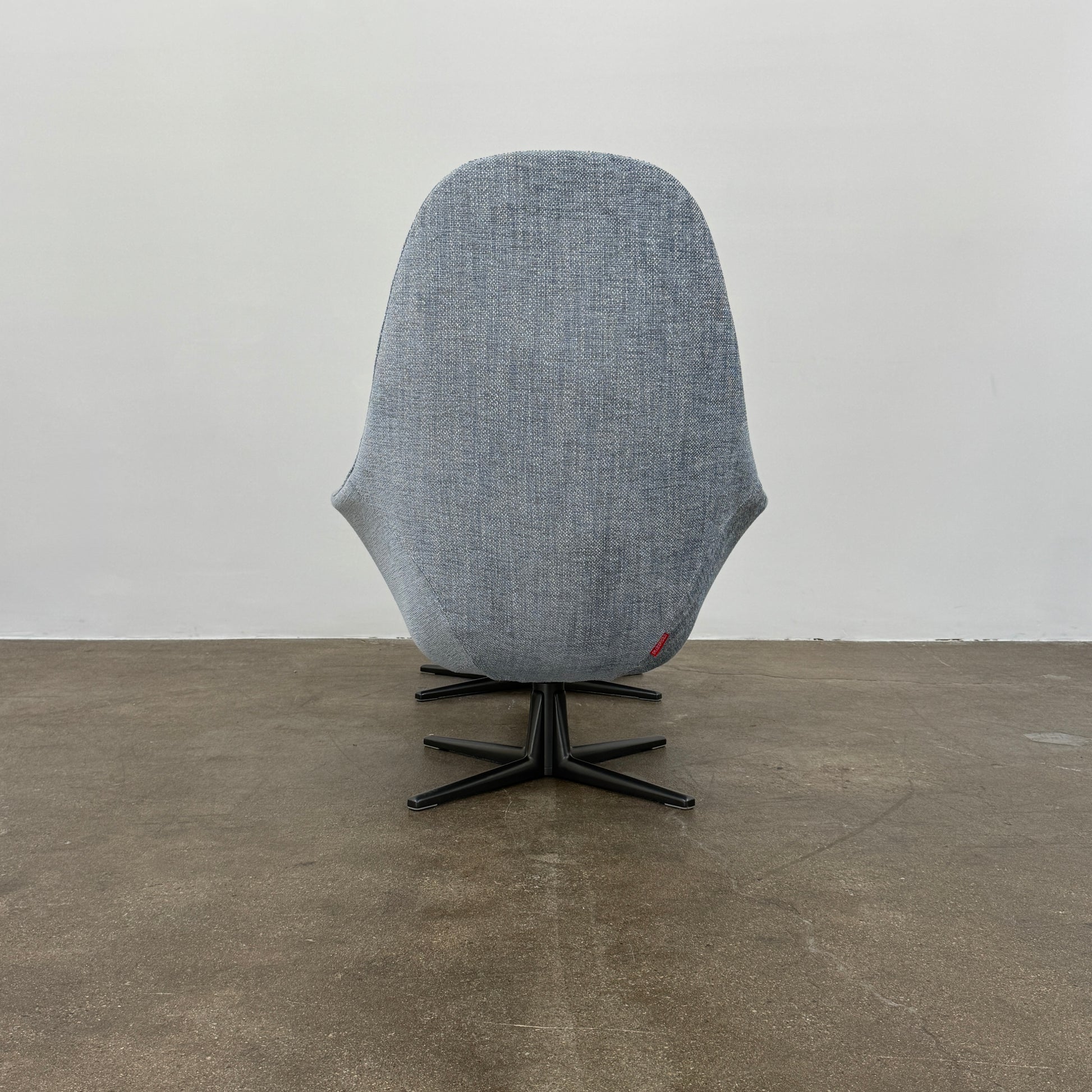 The Flexform Marlon Swivel Armchair and Ottoman, available with two covers, feature ergonomic design and black metal bases from Flexform, shown here in a modern gray finish against a plain white background.