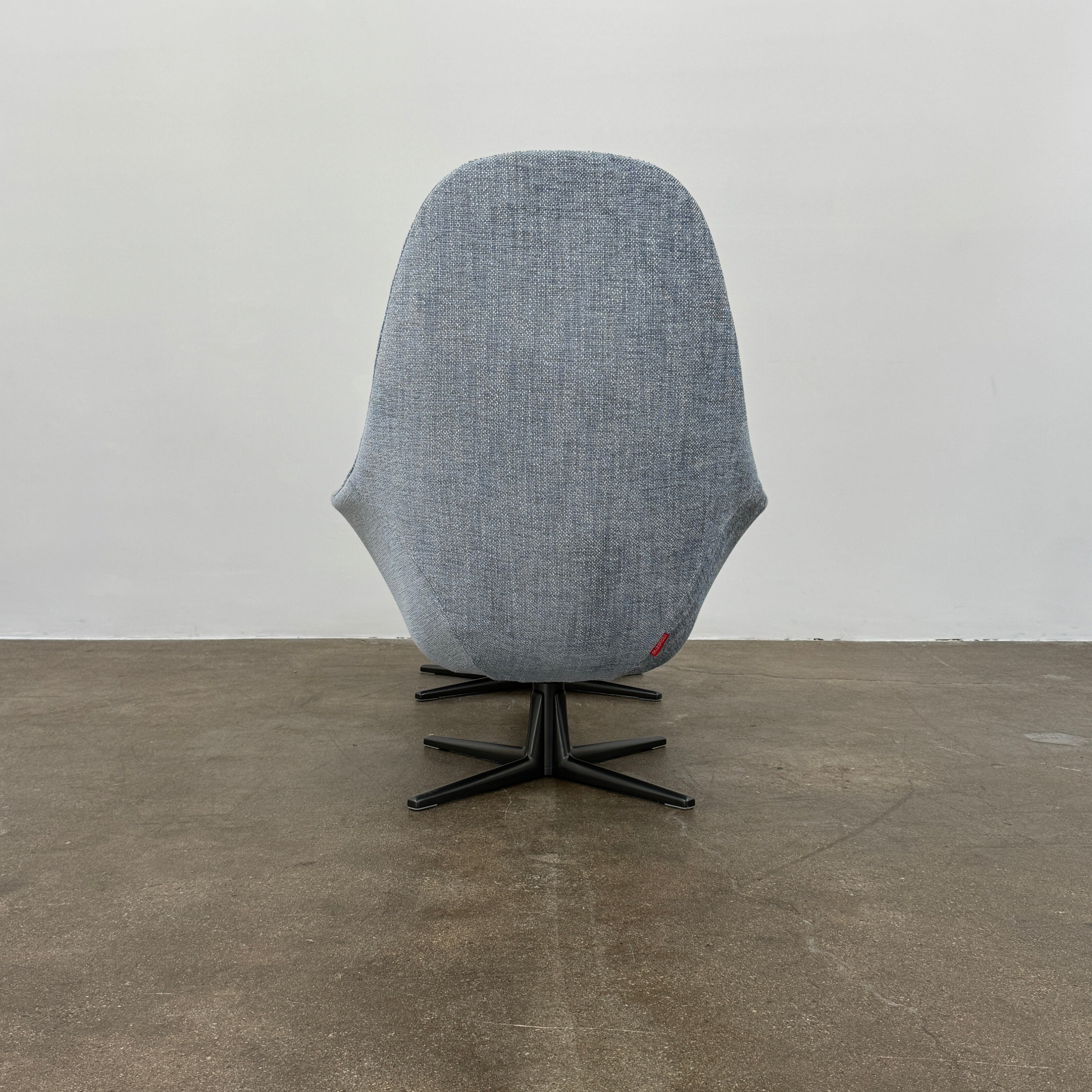 The Flexform Marlon Swivel Armchair and Ottoman, available with two covers, feature ergonomic design and black metal bases from Flexform, shown here in a modern gray finish against a plain white background.