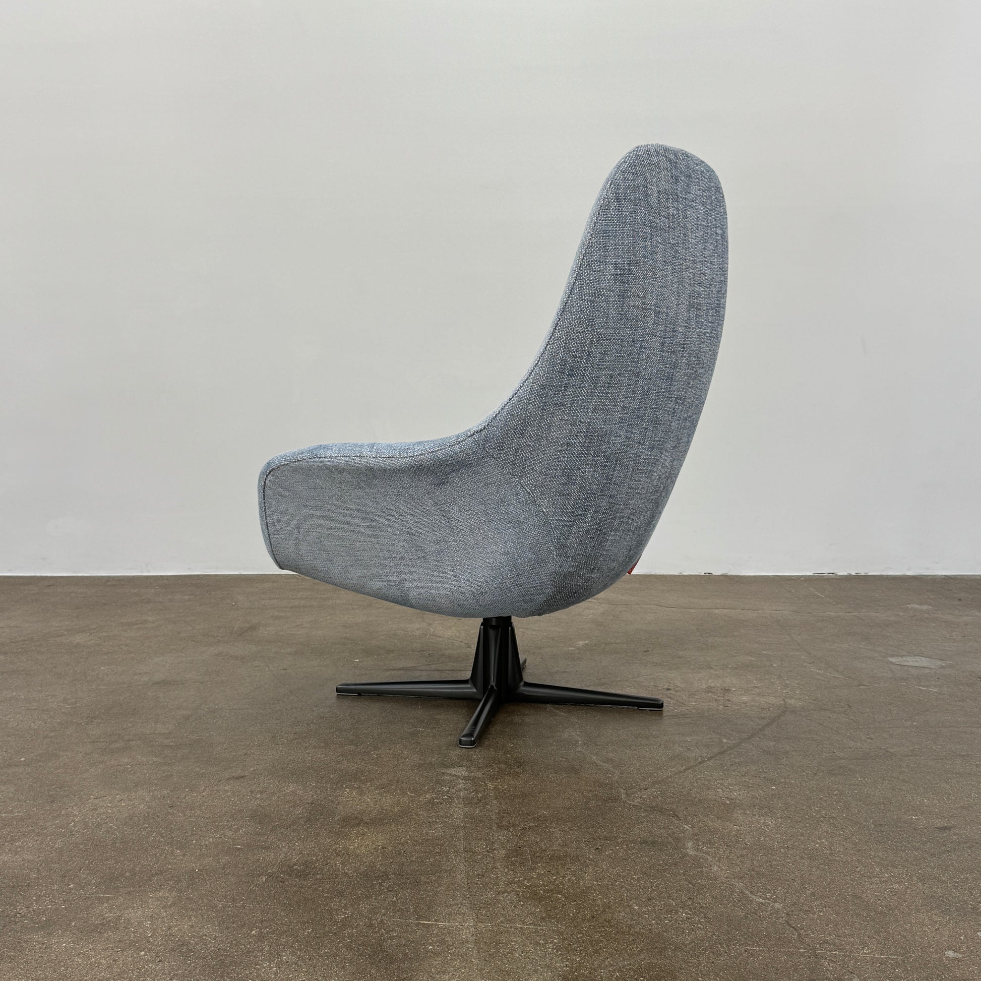 The Flexform Marlon Swivel Armchair and Ottoman, available with two covers, feature ergonomic design and black metal bases from Flexform, shown here in a modern gray finish against a plain white background.