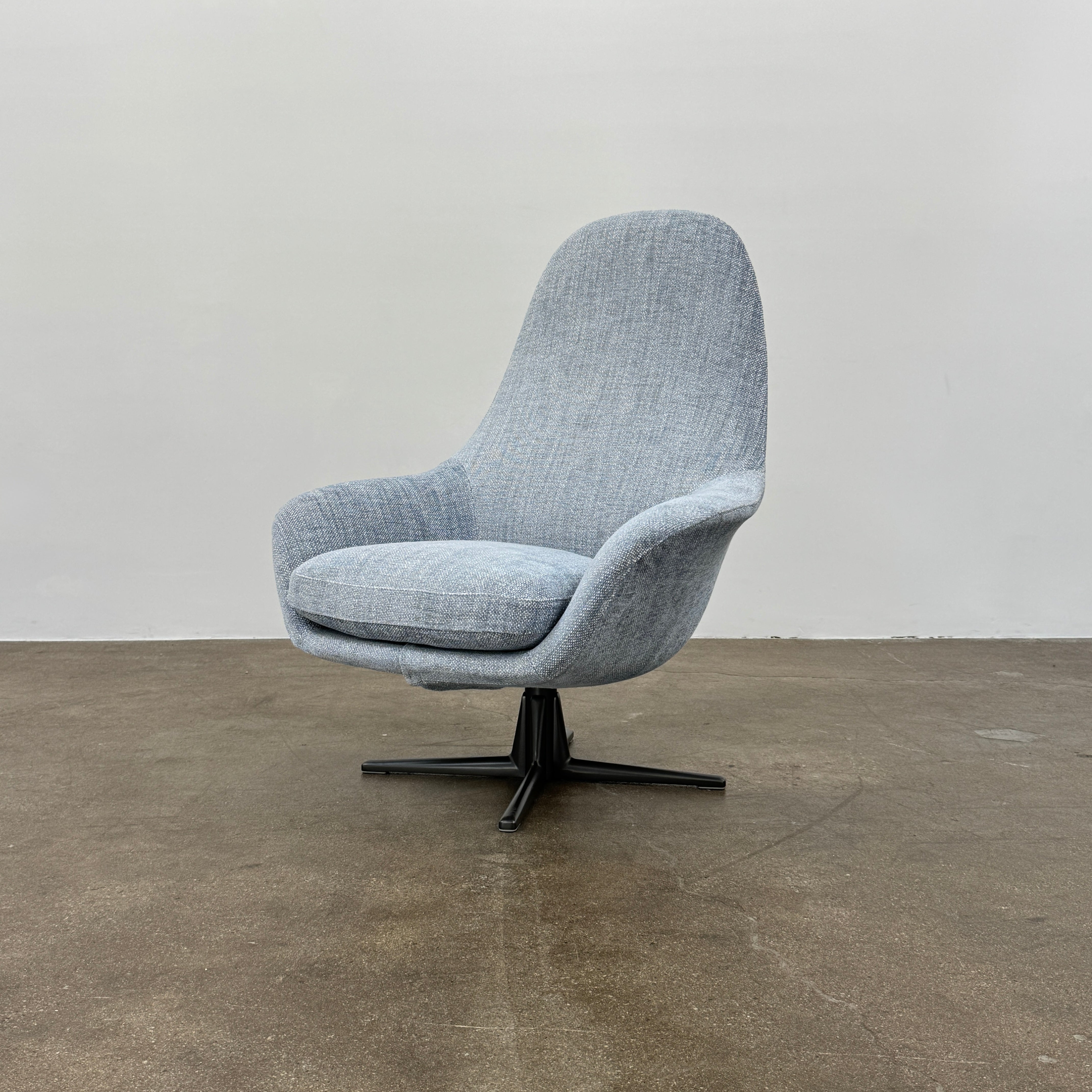 The Flexform Marlon Swivel Armchair and Ottoman, available with two covers, feature ergonomic design and black metal bases from Flexform, shown here in a modern gray finish against a plain white background.