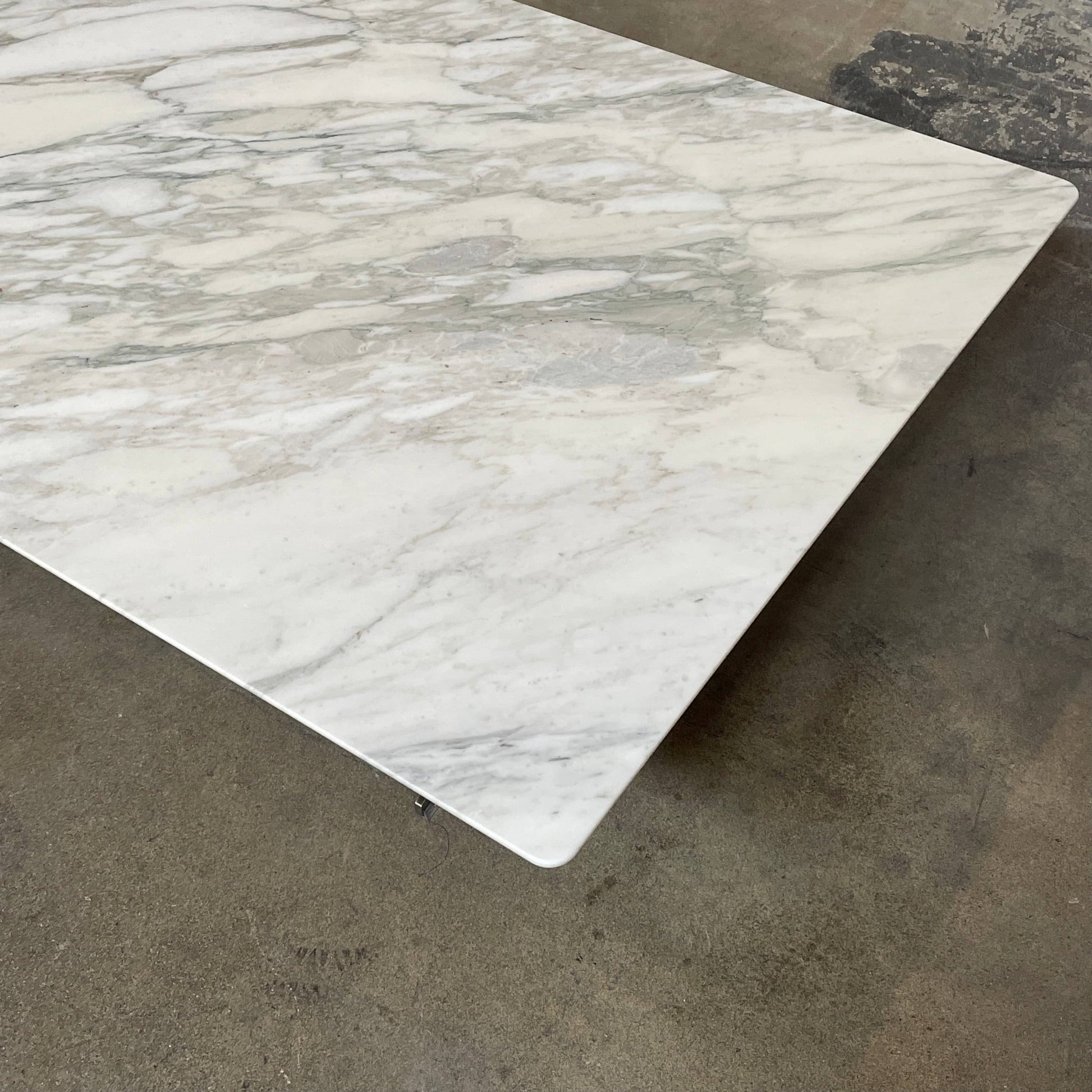 A Flexform Fly Marble Coffee Table with black legs on a white background.