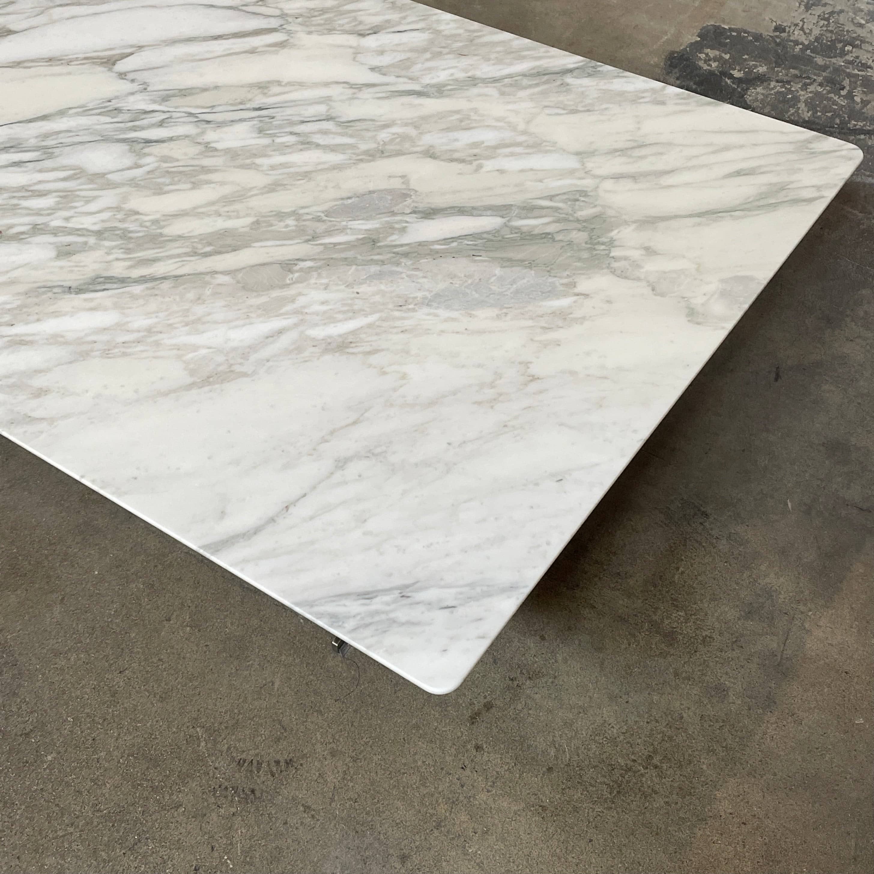A Flexform Fly Marble Coffee Table with black legs on a white background.