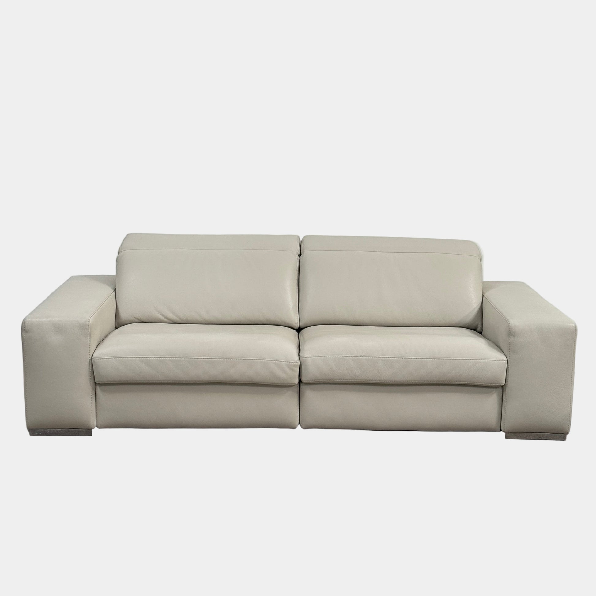 The Roche Bobois Leather Sofa With Movable Headrest features a modern beige design, wide armrests, metal legs, and an adjustable headrest—ideal for any contemporary living space.