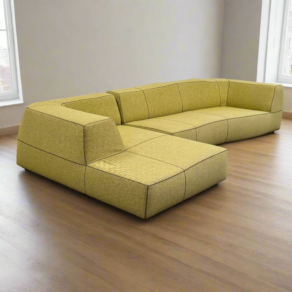 The B&B Italia Bend Sectional Sofa by B&B Italia features olive green fabric, black accent stitching, low backrests, and a geometric design inspired by Patricia Urquiola, shown on a plain white background.