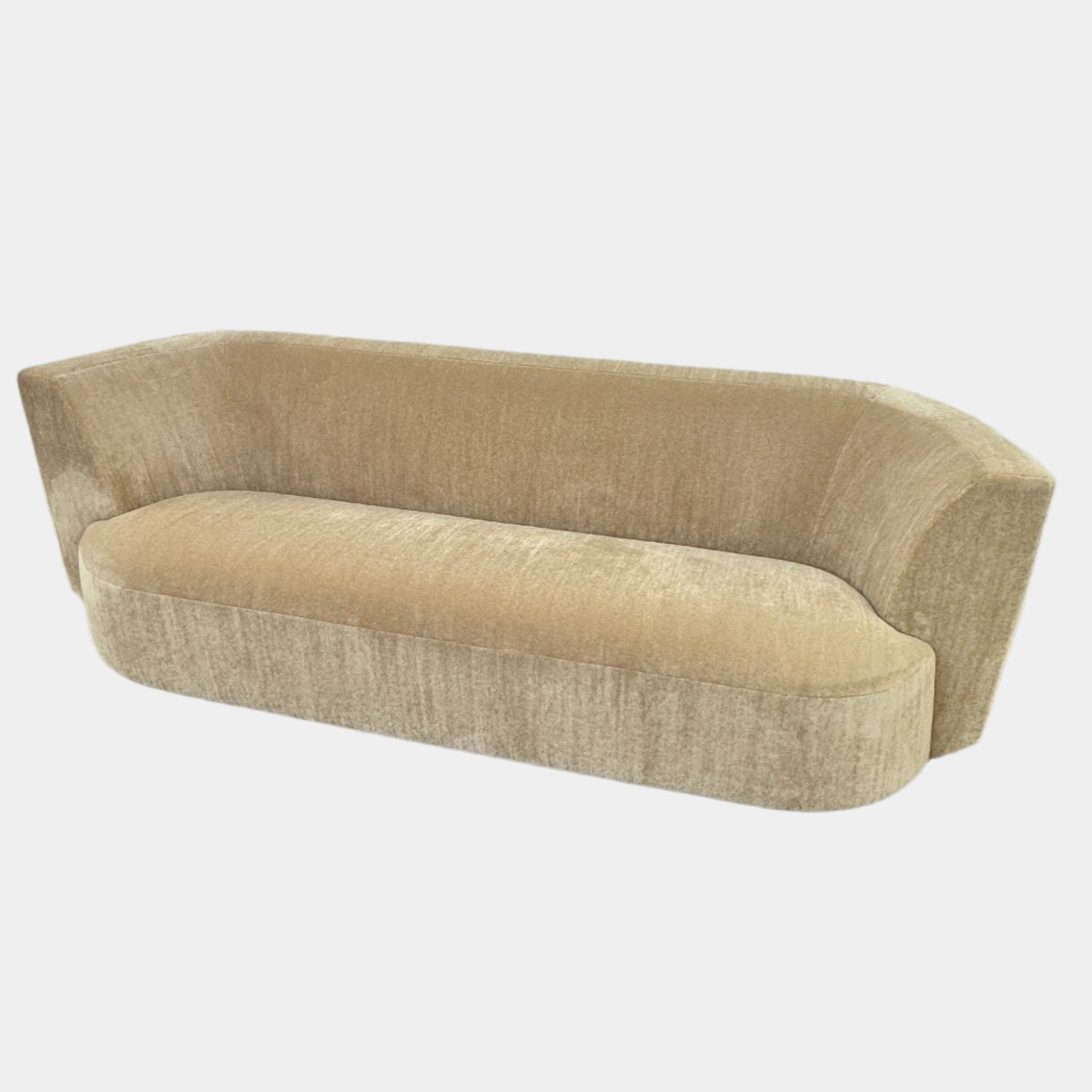 The tan, modern Holly Hunt Caste Malta Sofa with rounded edges sits stylishly on a polished concrete floor against a white wall, showcasing minimalist design inspired by Holly Hunt’s signature aesthetic.