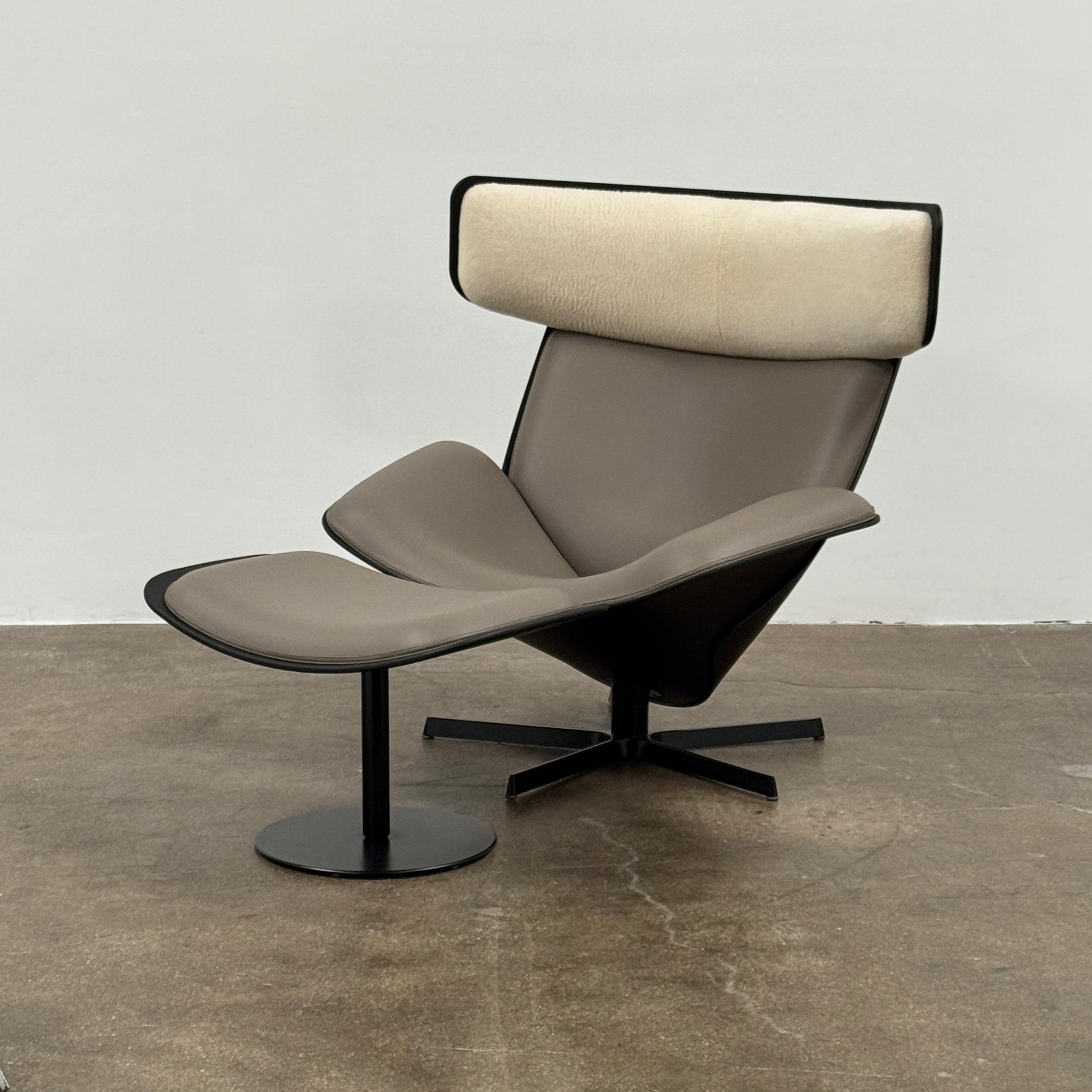 The B&B Italia Almora Chair and Ottoman in modern gray and black are swivel lounge pieces by B&B Italia, displayed on a white background.