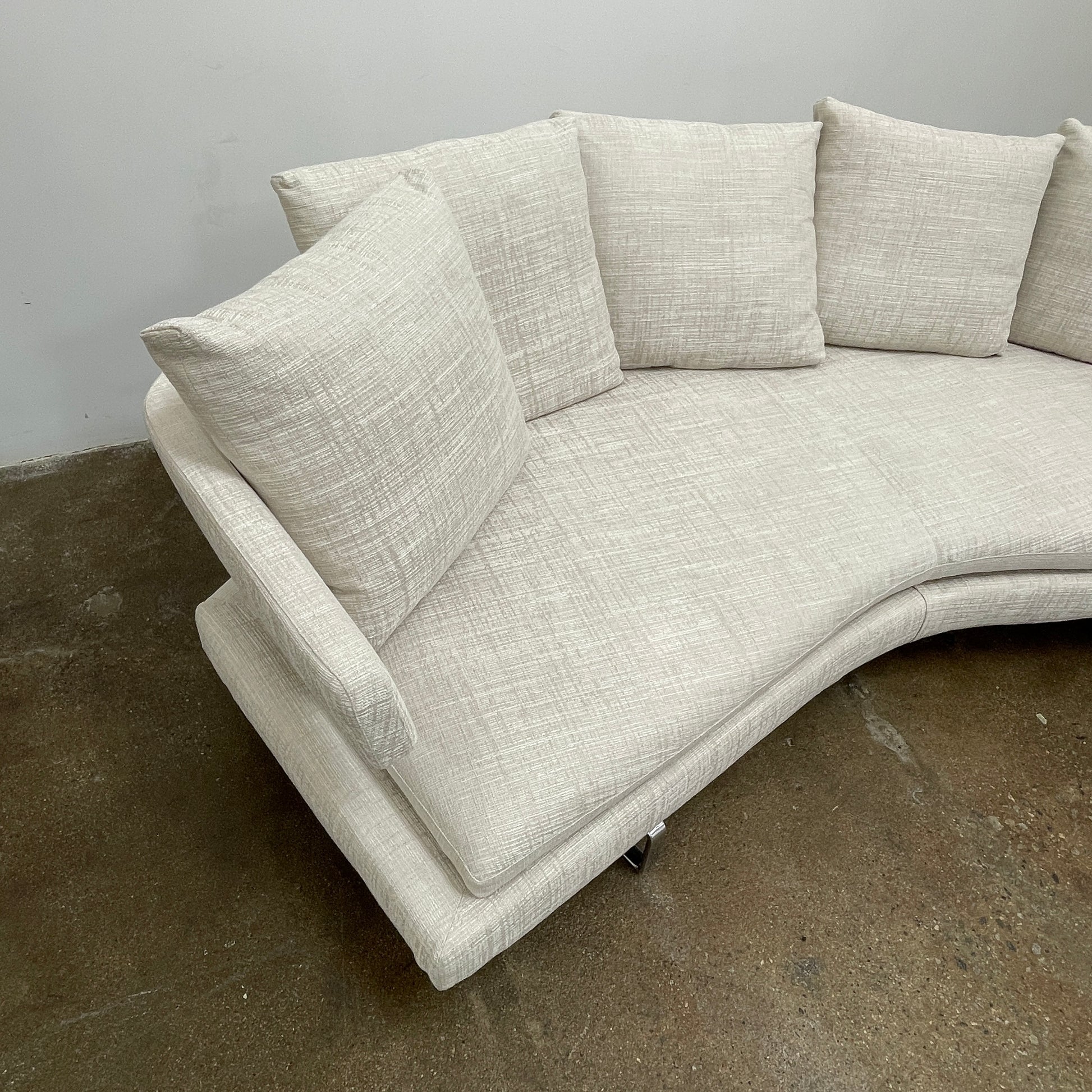 Experience the B&B Italia Arne Sofa, a modern off-white masterpiece with five plush cushions and cylindrical armrests. Designed by Antonio Citterio, it features sleek metal legs set against a crisp background.