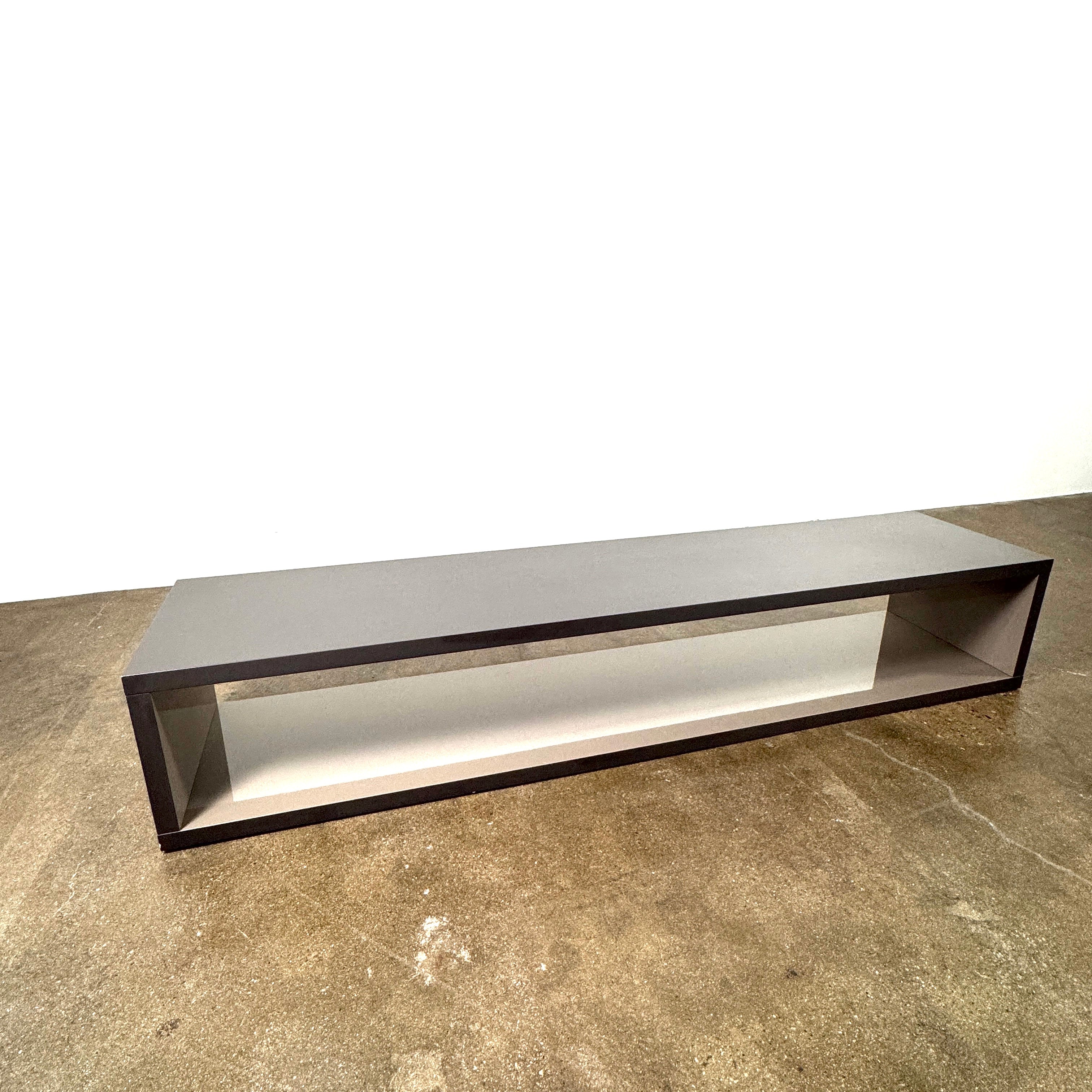 The B&B Italia Frank Low Console by B&B Italia features a sleek black rectangular frame with clear glass, making it an ideal modern low sofa back table inspired by contemporary elegance.