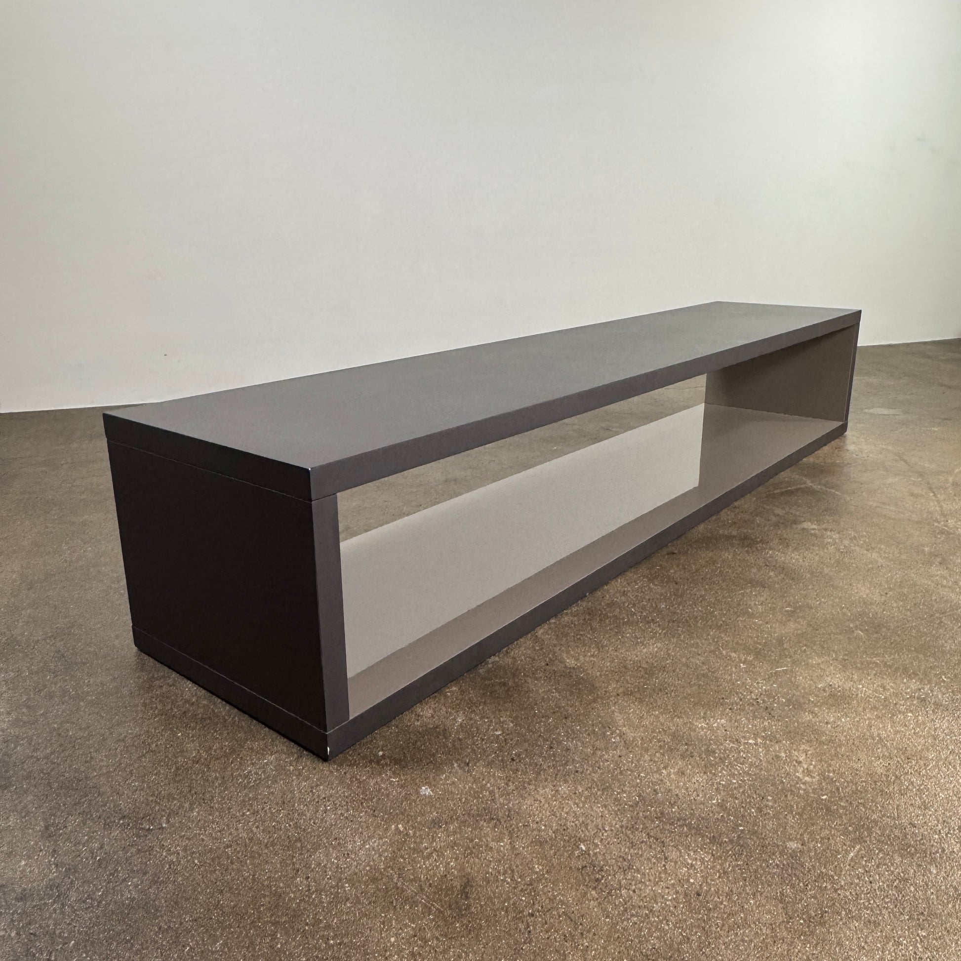 The B&B Italia Frank Low Console by B&B Italia features a sleek black rectangular frame with clear glass, making it an ideal modern low sofa back table inspired by contemporary elegance.