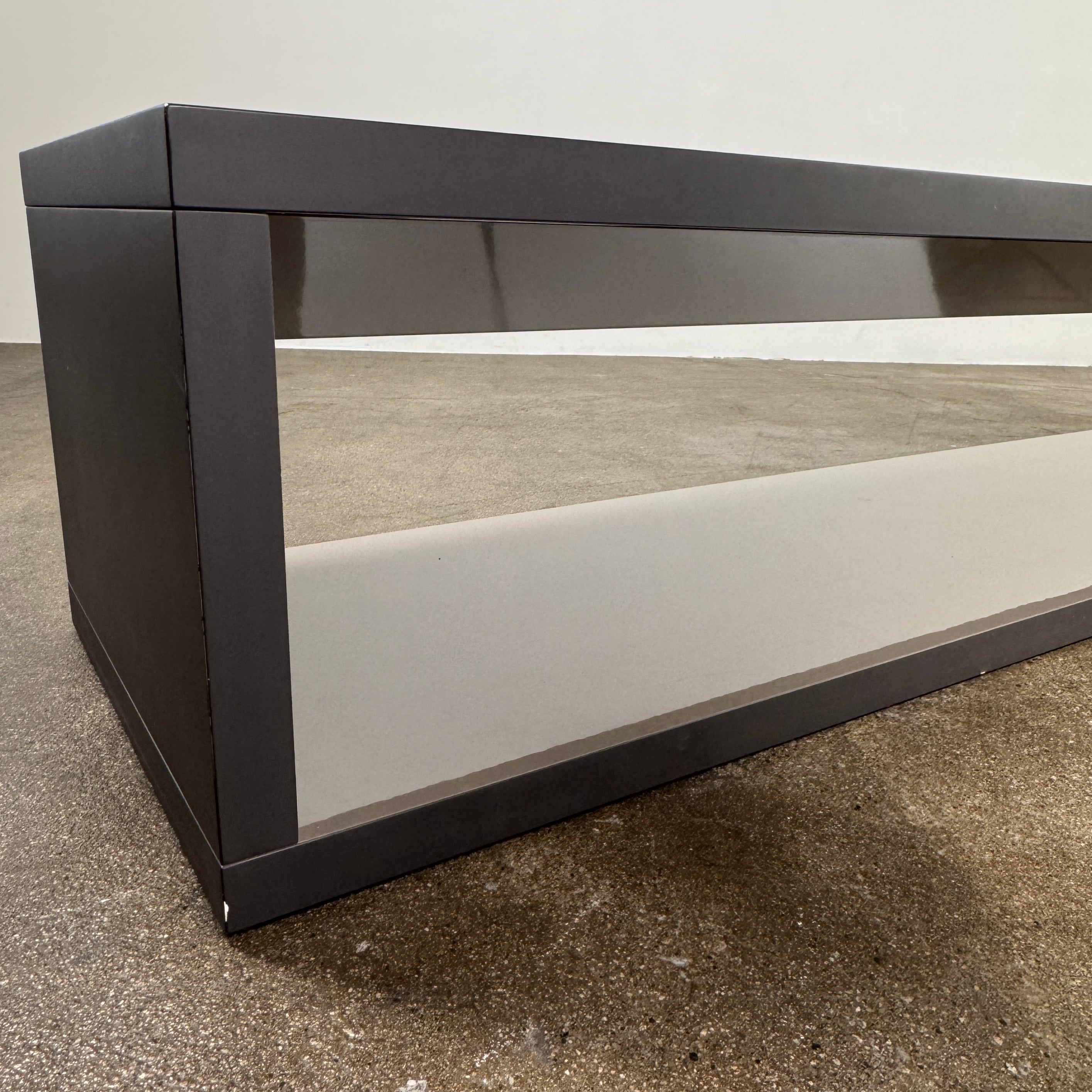 The B&B Italia Frank Low Console by B&B Italia features a sleek black rectangular frame with clear glass, making it an ideal modern low sofa back table inspired by contemporary elegance.
