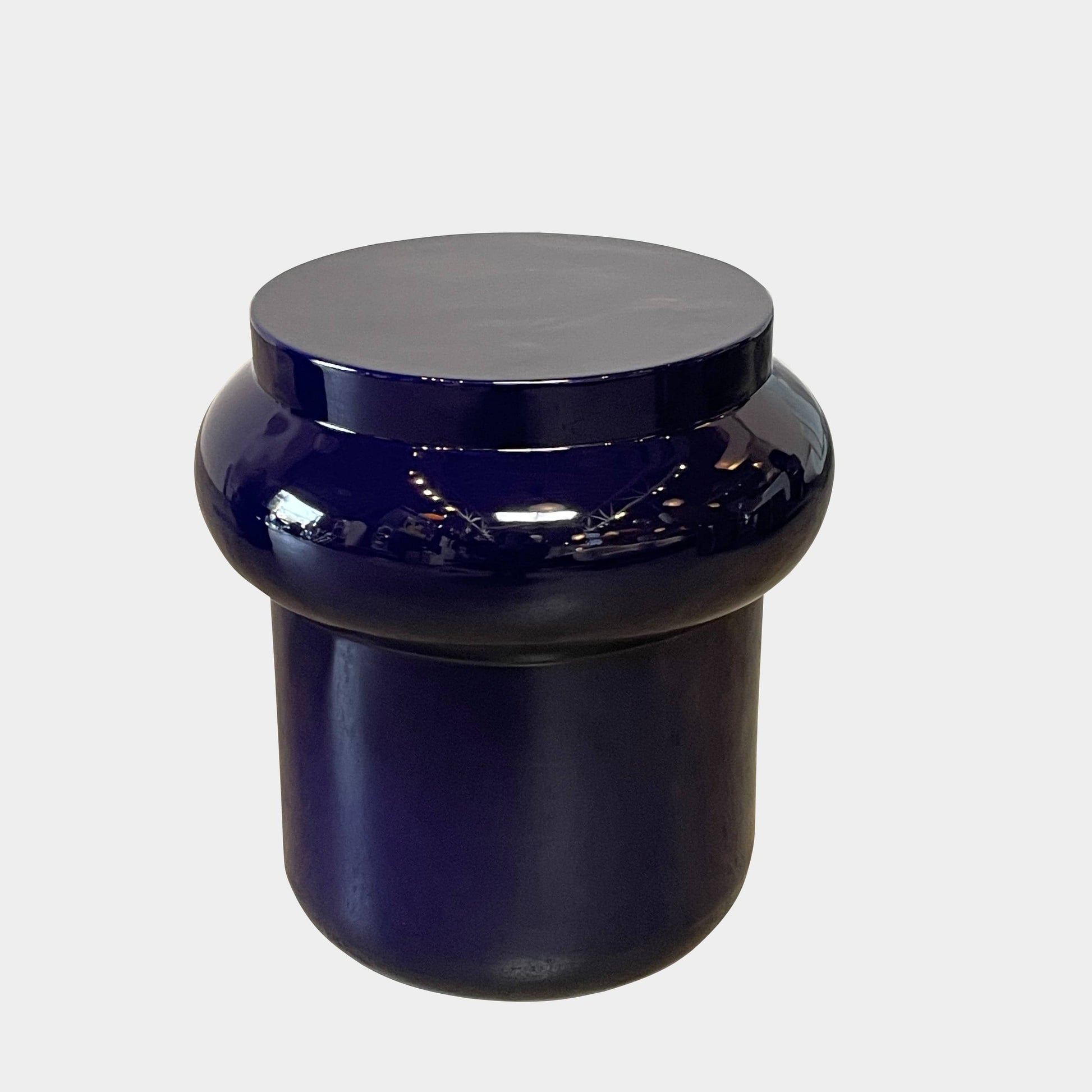 The Delcourt Collection Dot table by Delcourt Collection, designed by Charles Kalpakian, features a glossy ultramarine blue glaze and a dark blue cylindrical form with a wide, rounded top edge, set against a plain white background.