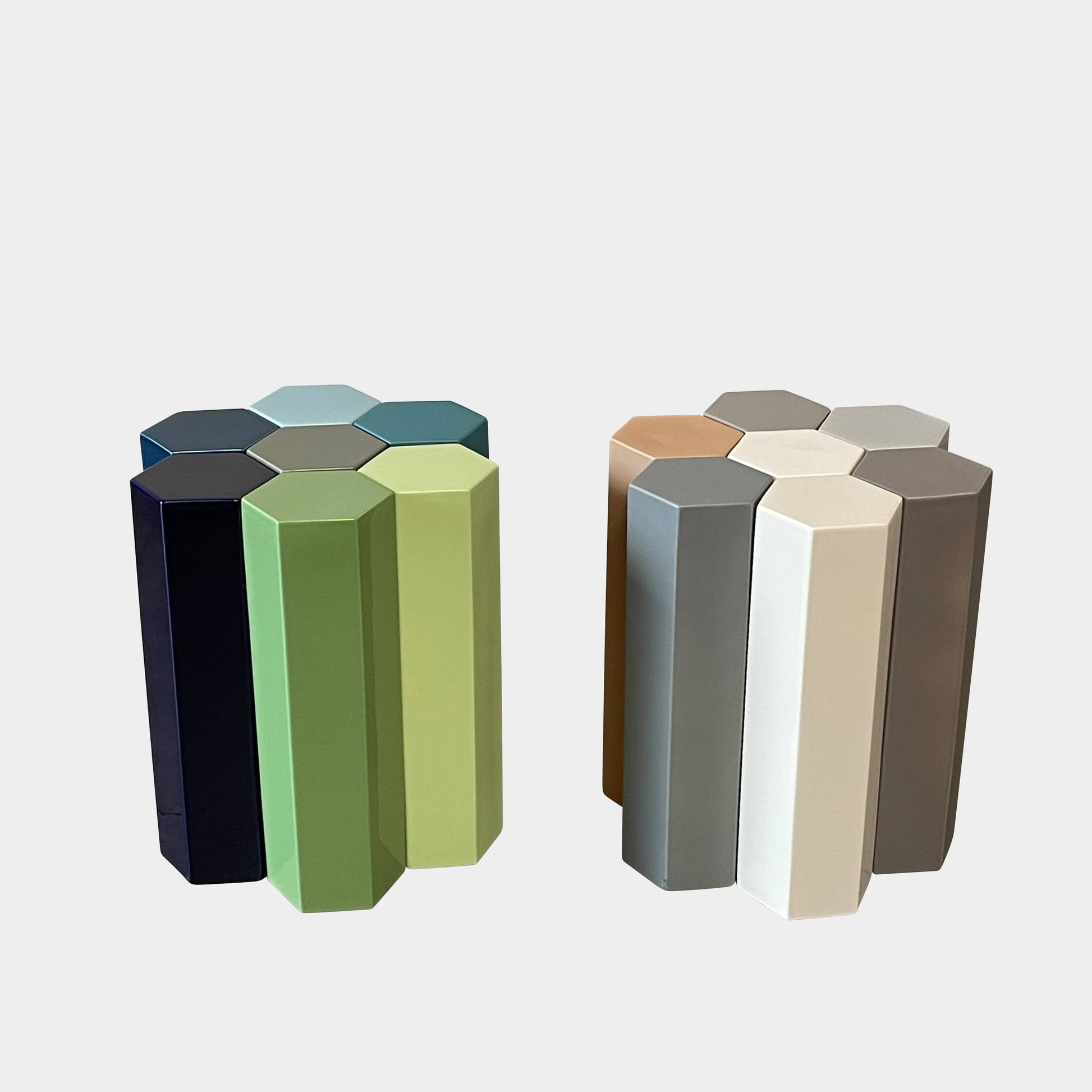 The Delcourt Collection MUC 7 Side Tables feature interconnected ceramic hexagons in green, blue, brown, and gray on a light gray background. Echoing Christophe Delcourt's design ethos, these versatile pieces enhance any space with style and functionality.