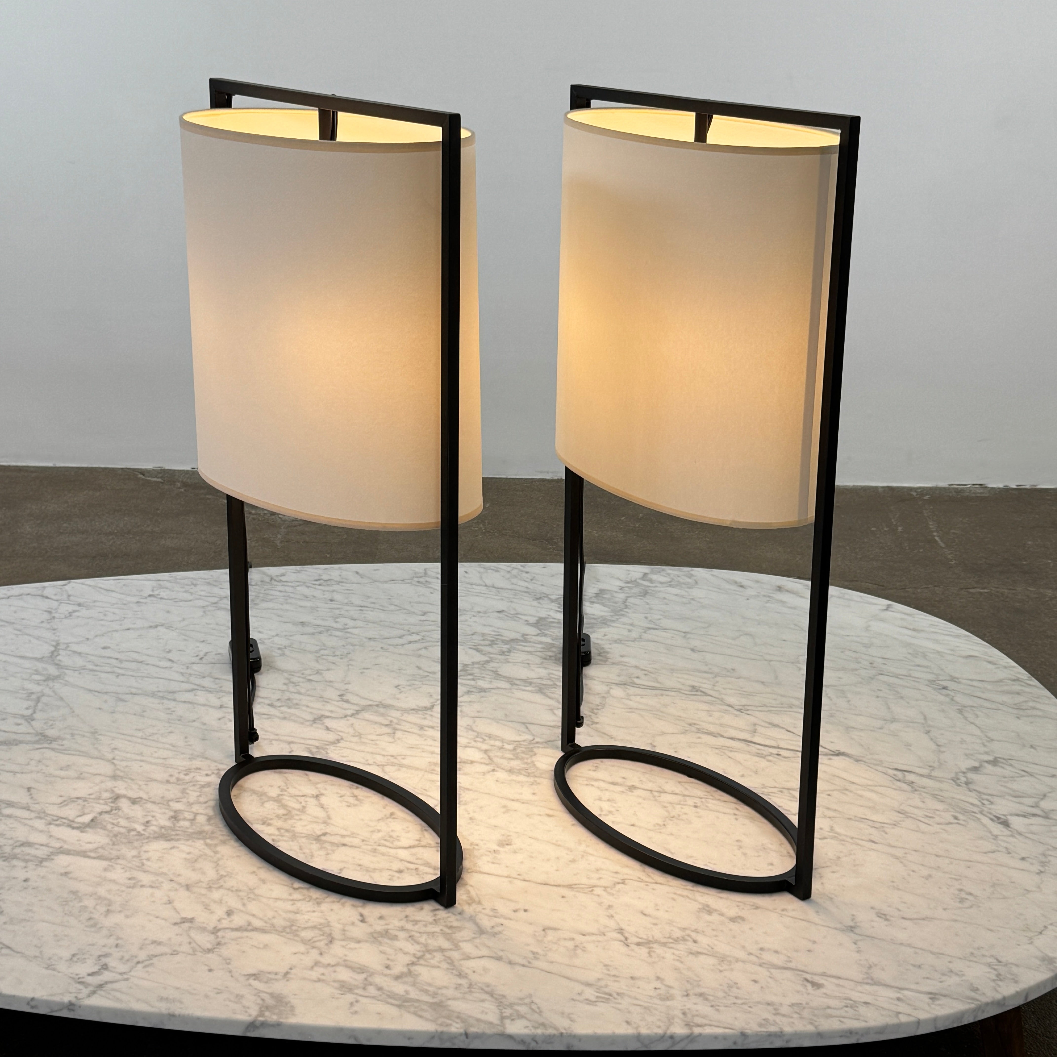 The Holly Hunt Pattern Table Lamp by Holly Hunt features a white cylindrical shade and black metal frame, offering modern style and dimmable lighting—perfect as a stylish reading lamp on any white background.