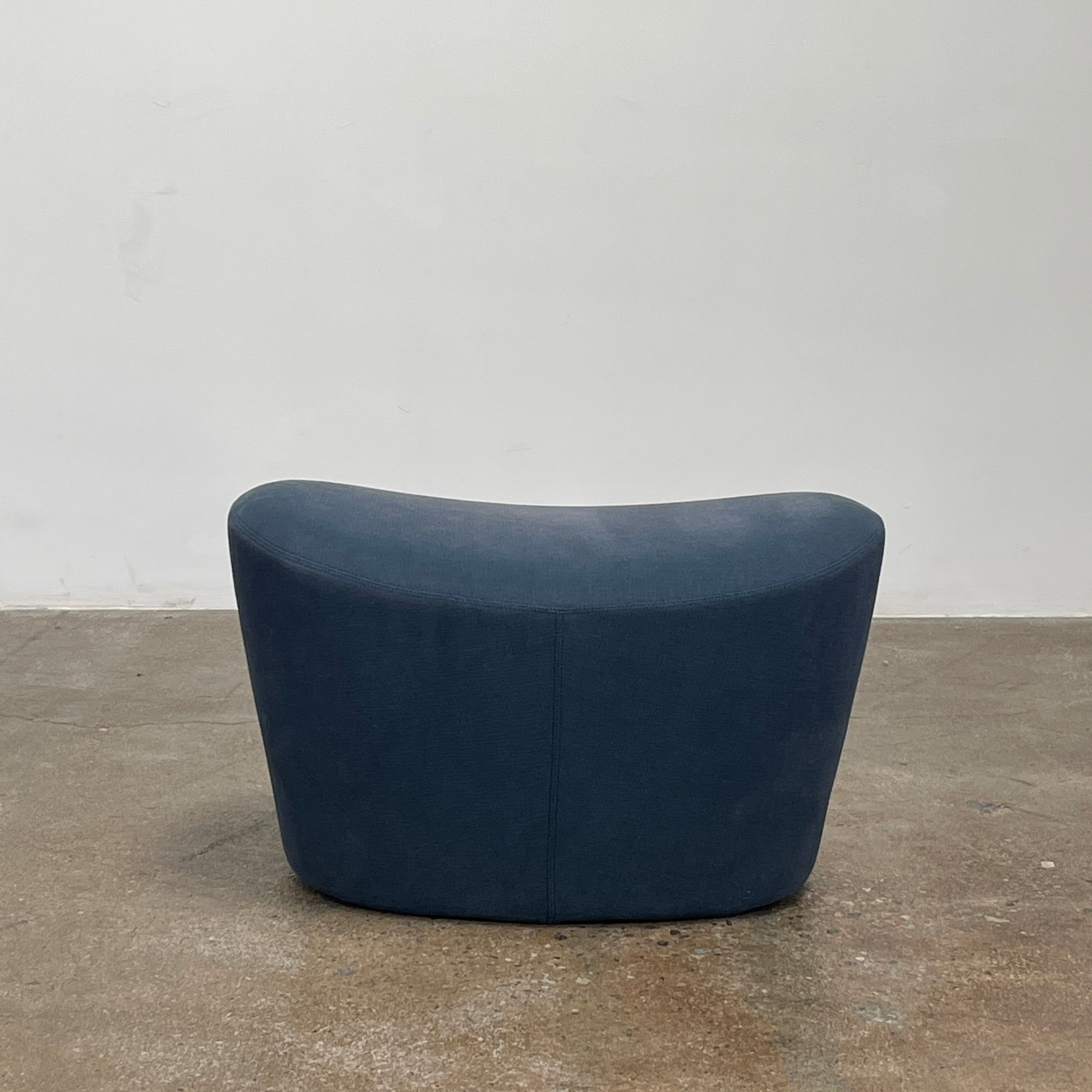 The B&B Italia Grande Papilio Swivel Chair with Ottoman features a modern design inspired by Naoto Fukasawa, with a dark blue finish, wide seat, curved armrests, and a high winged backrest—a signature piece from B&B Italia.