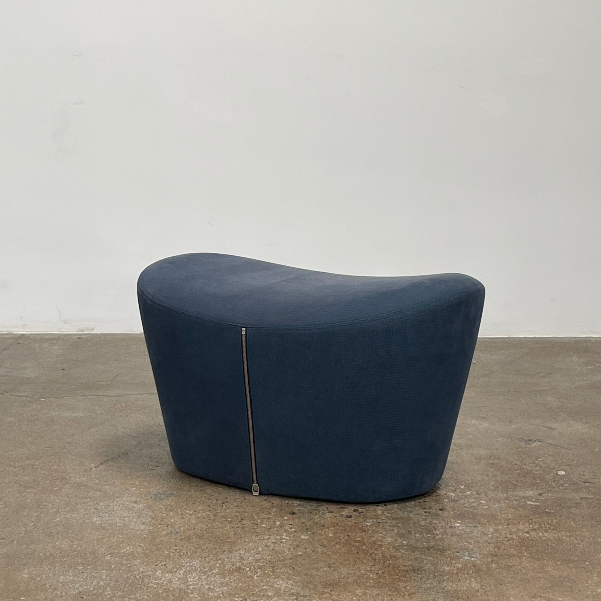 The B&B Italia Grande Papilio Swivel Chair with Ottoman features a modern design inspired by Naoto Fukasawa, with a dark blue finish, wide seat, curved armrests, and a high winged backrest—a signature piece from B&B Italia.