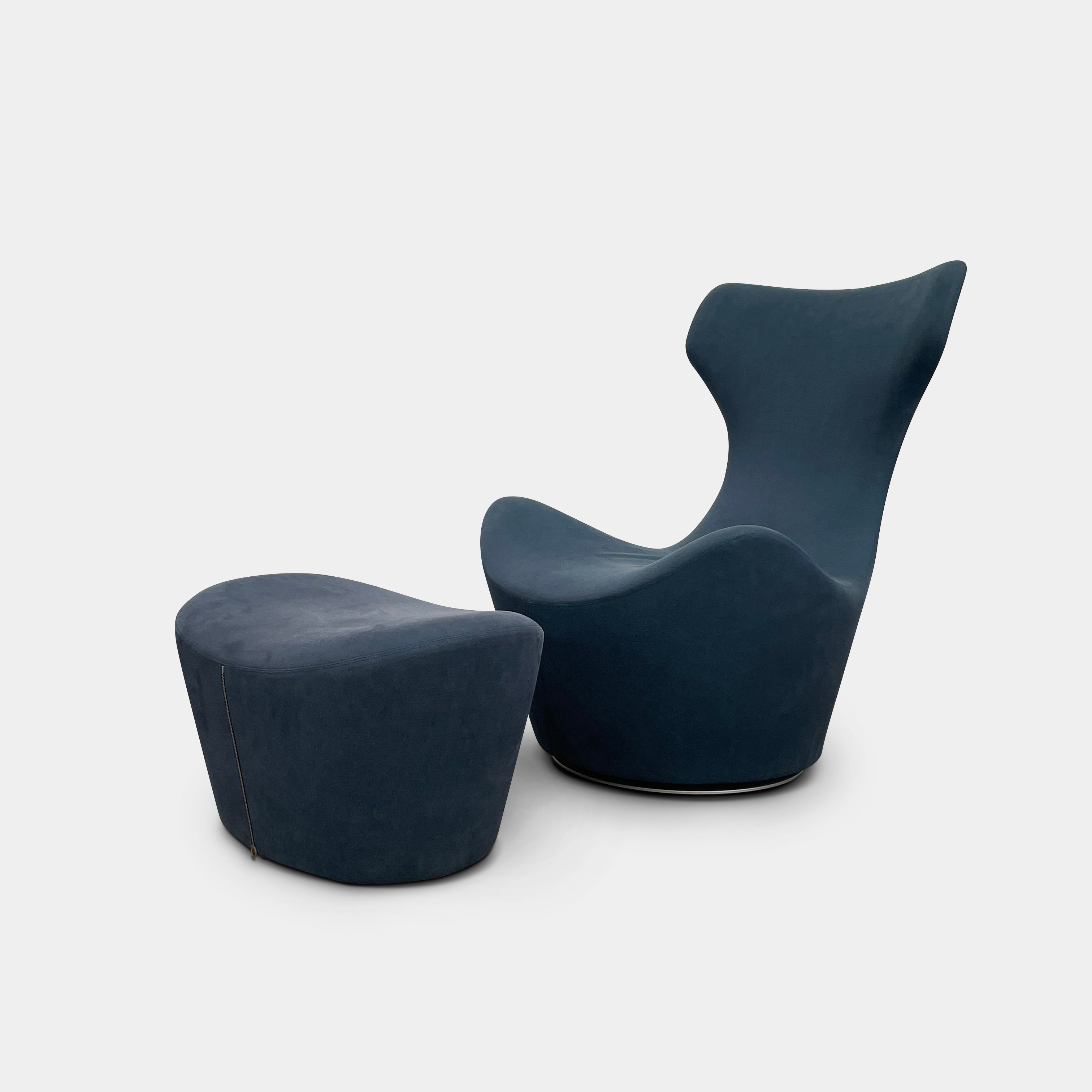 The B&B Italia Grande Papilio Swivel Chair with Ottoman features a modern design inspired by Naoto Fukasawa, with a dark blue finish, wide seat, curved armrests, and a high winged backrest—a signature piece from B&B Italia.