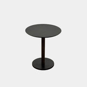 The Maruni Hiroshima Side Table by Maruni features a small, round black oak top and a single central pedestal base, shown against a plain light gray background.