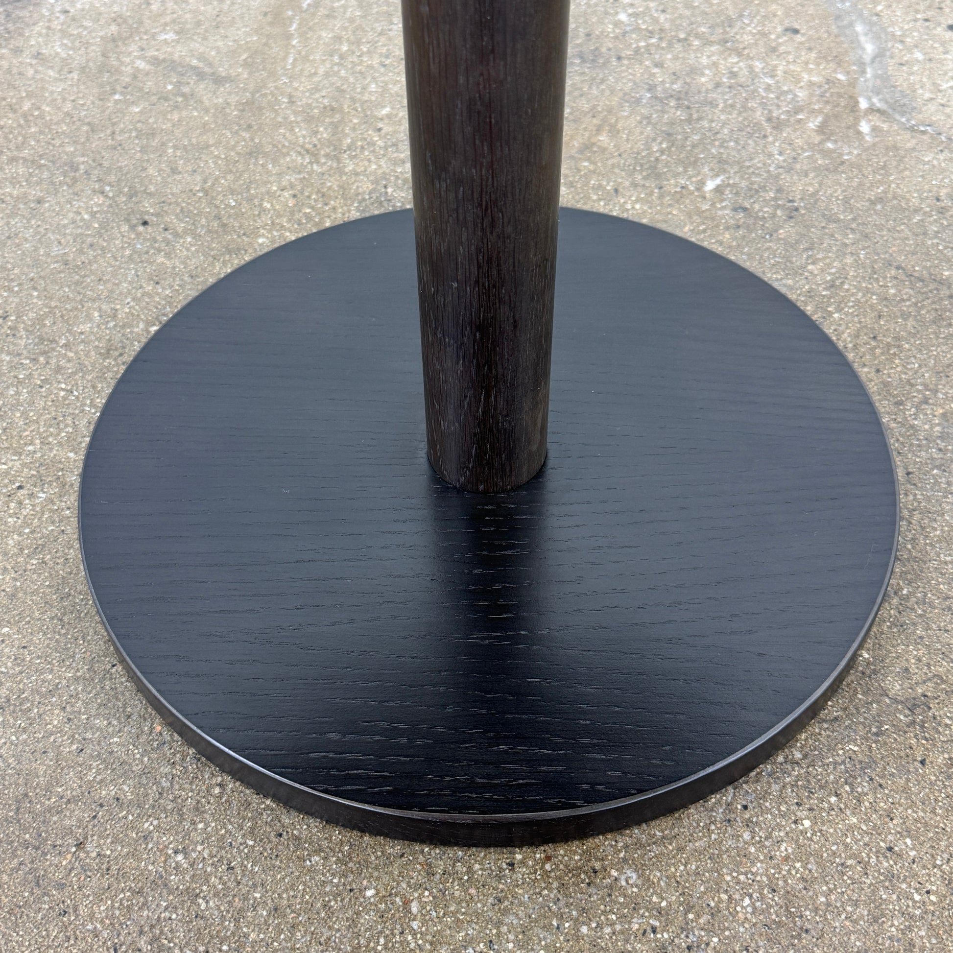 The Maruni Hiroshima Side Table by Maruni features a small, round black oak top and a single central pedestal base, shown against a plain light gray background.