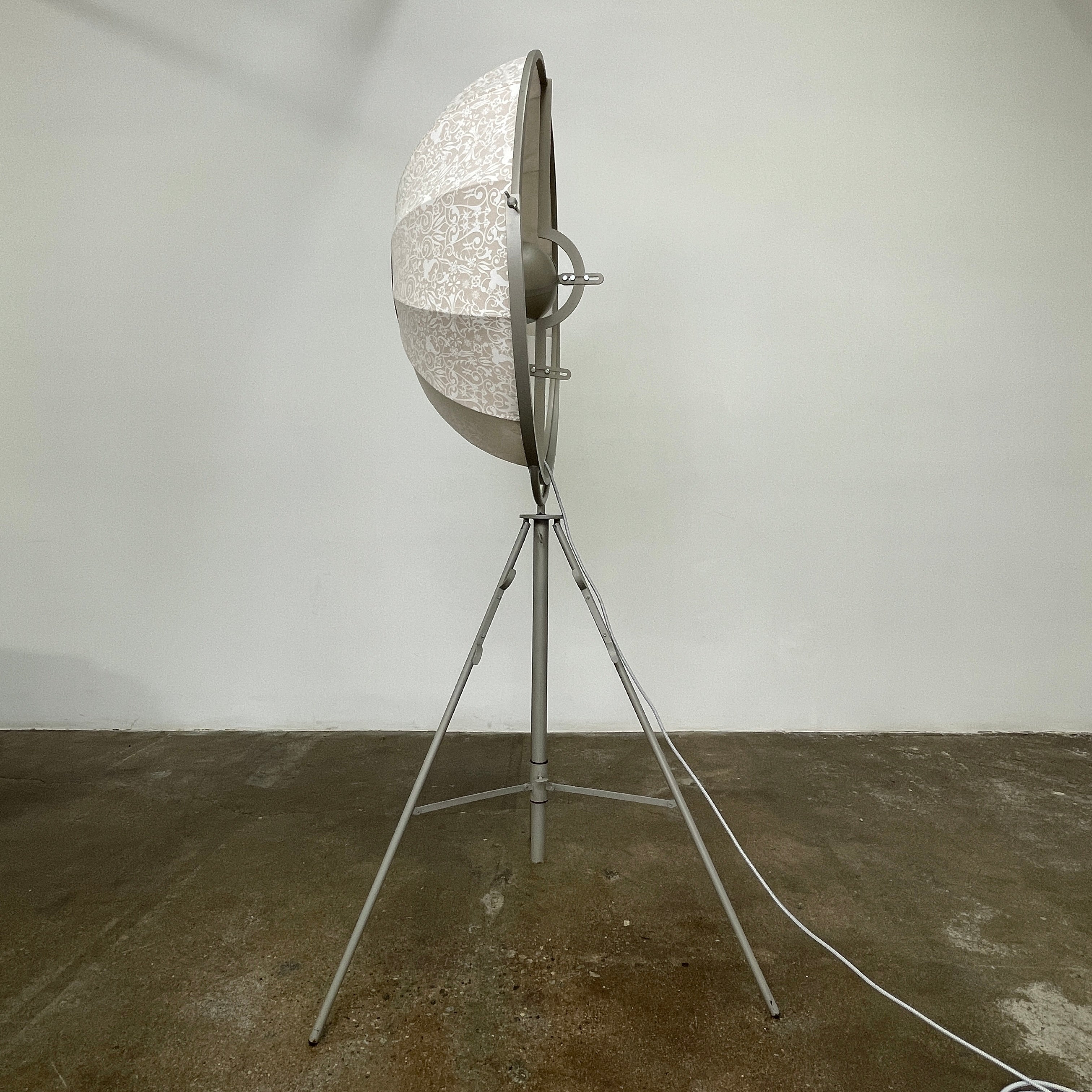 The Pallucco Italia Fortuny Ornament Floor Lamp, with its visible bulb and patterned spherical shade, gracefully stands on a plain white background, epitomizing the elegance of Pallucco Italia.