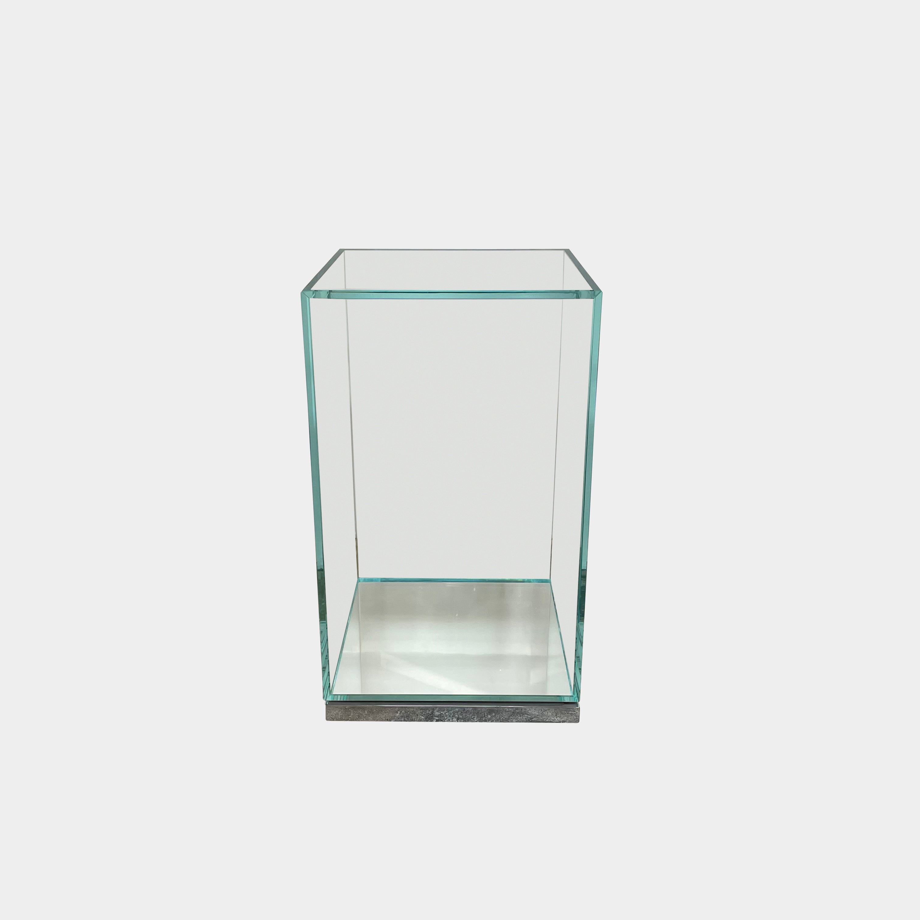 A clear glass rectangular display case with a flat metal base, inspired by the Cassina Volage side table by Philippe Starck for Cassina, photographed against a plain white background.