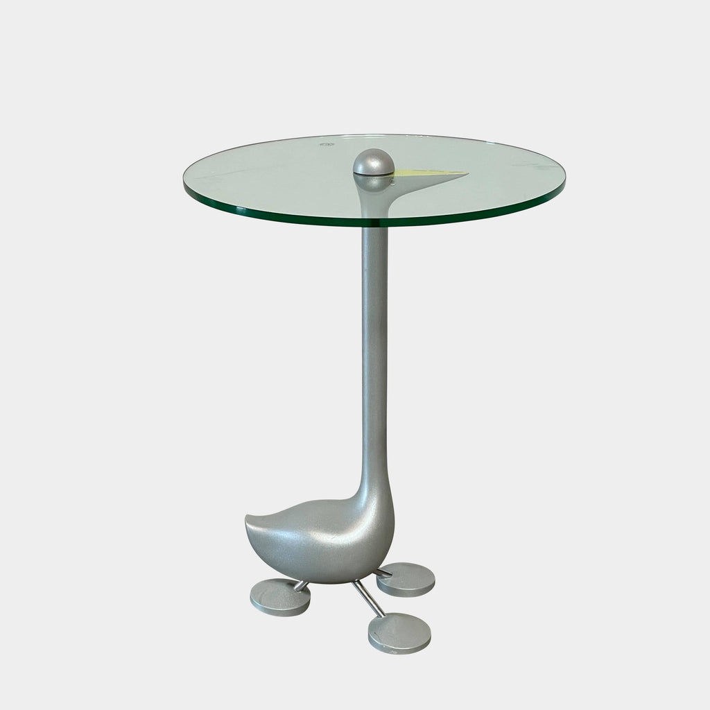 The Zanotta Edizioni Sirfo "Goose" table, designed by Alessandro Mendini, features a stunning glass top with a whimsical bird perched on it.