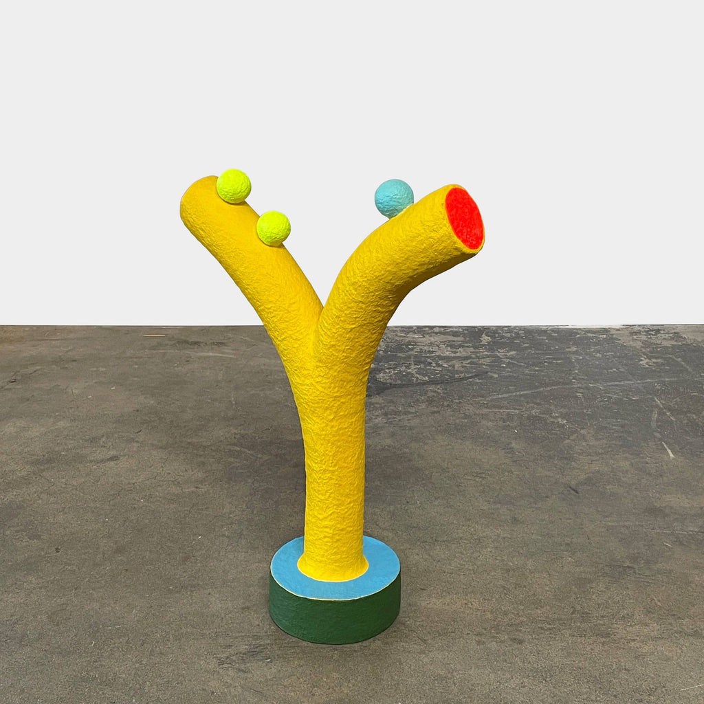 A yellow Gemel Sculpture No.99 with a blue ball in the middle created by Terri Chiao and Adam Frezza as part of their CHIAOZZA Gemel Sculpture series.