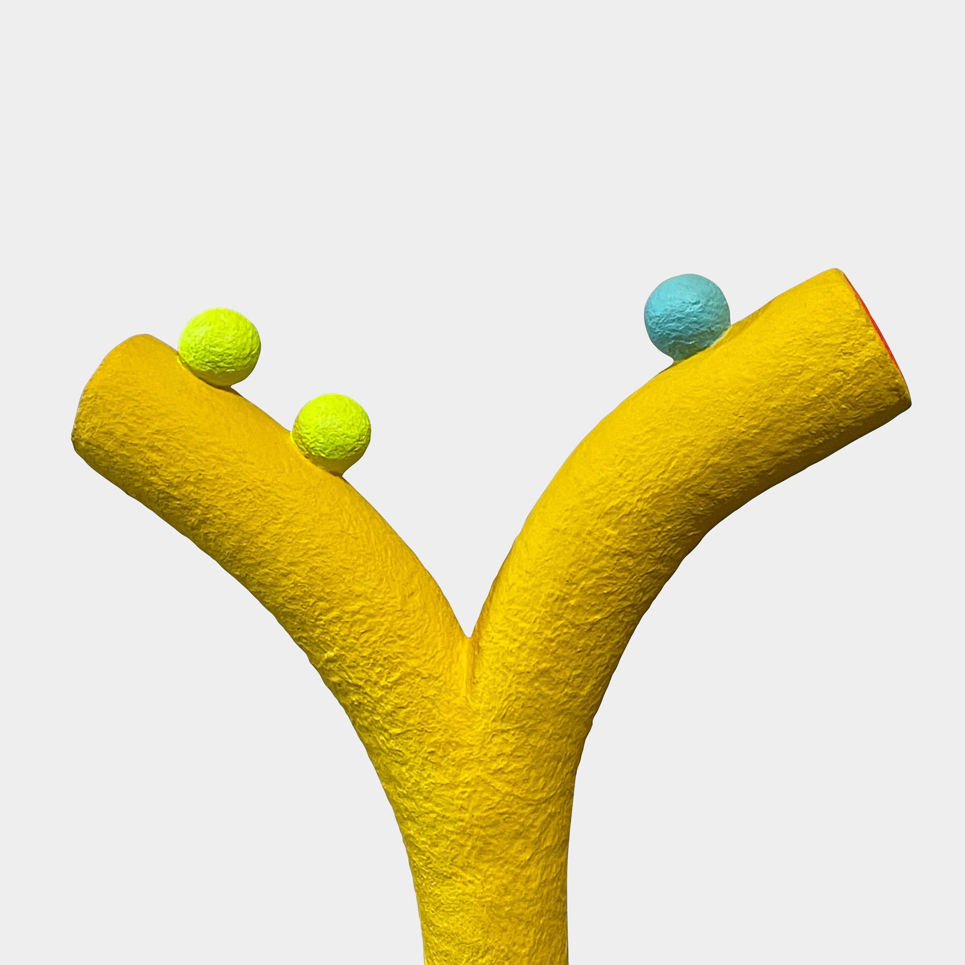 A yellow Gemel Sculpture No.99 with a blue ball in the middle created by Terri Chiao and Adam Frezza as part of their CHIAOZZA Gemel Sculpture series.