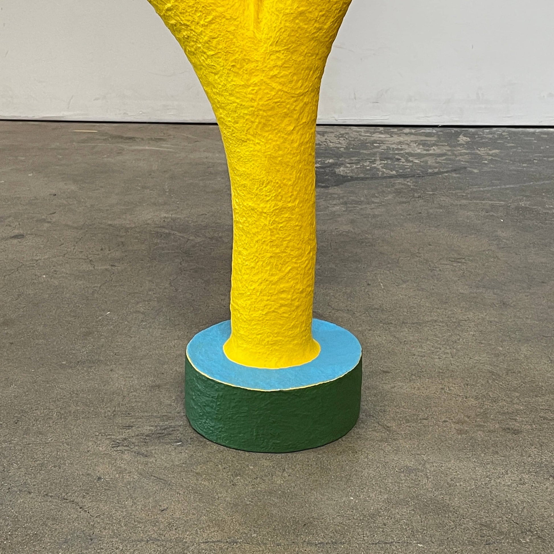 A yellow Gemel Sculpture No.99 with a blue ball in the middle created by Terri Chiao and Adam Frezza as part of their CHIAOZZA Gemel Sculpture series.
