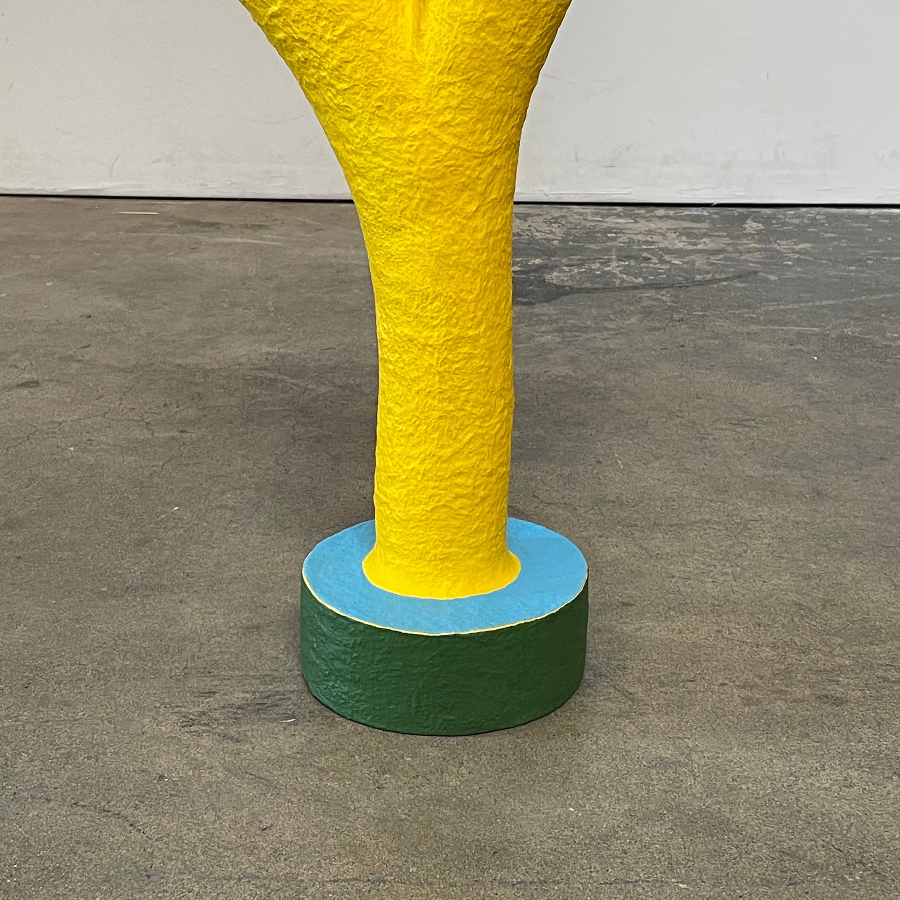 A yellow Gemel Sculpture No.99 with a blue ball in the middle created by Terri Chiao and Adam Frezza as part of their CHIAOZZA Gemel Sculpture series.