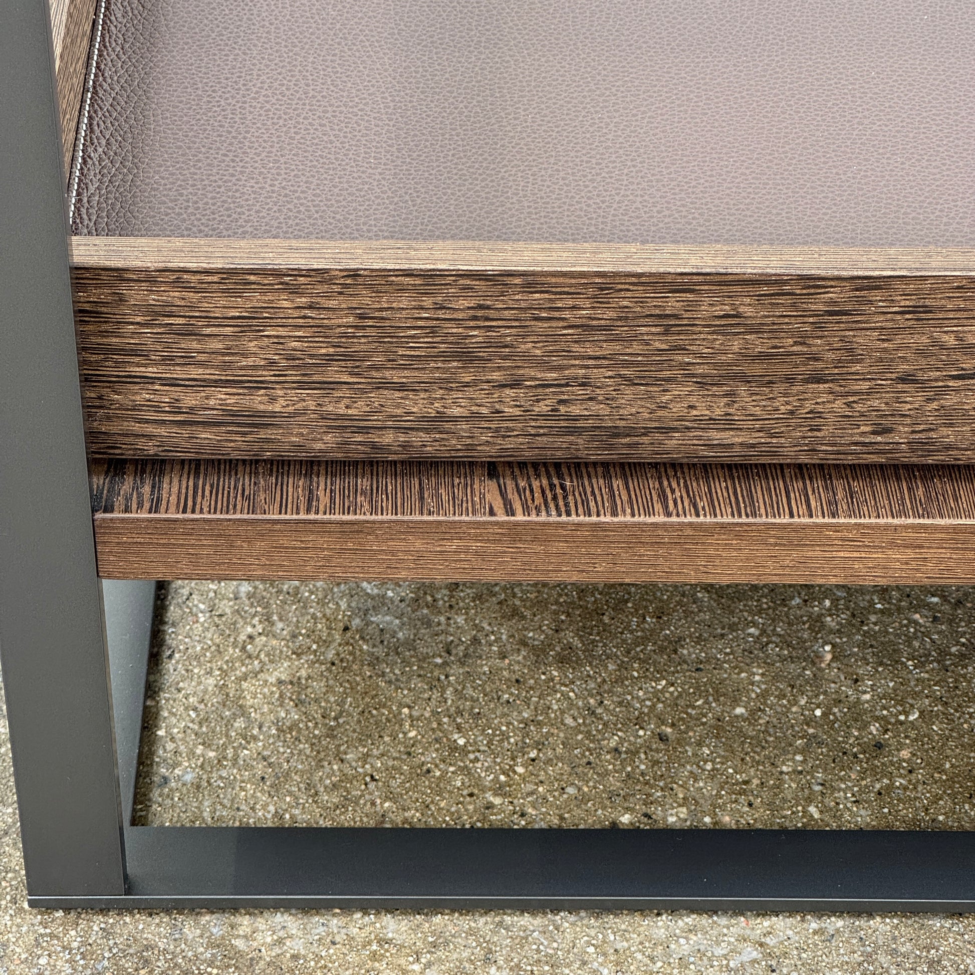 The Maxalto Lithos Coffee Table by Maxalto features a square metal frame, glass top, and two wooden lower shelves—one slightly raised—inspired by the original design. Shown against a plain white background.