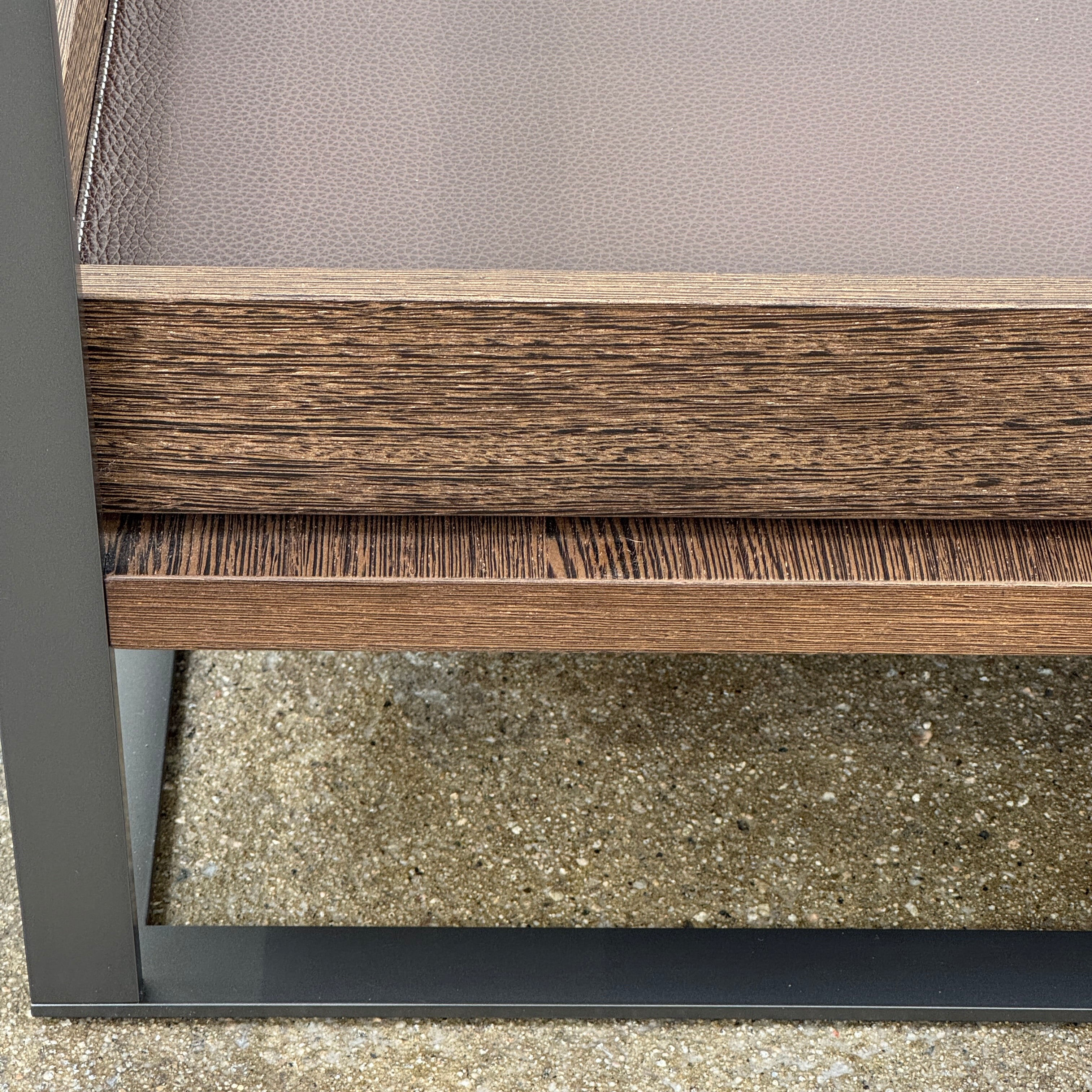 The Maxalto Lithos Coffee Table by Maxalto features a square metal frame, glass top, and two wooden lower shelves—one slightly raised—inspired by the original design. Shown against a plain white background.